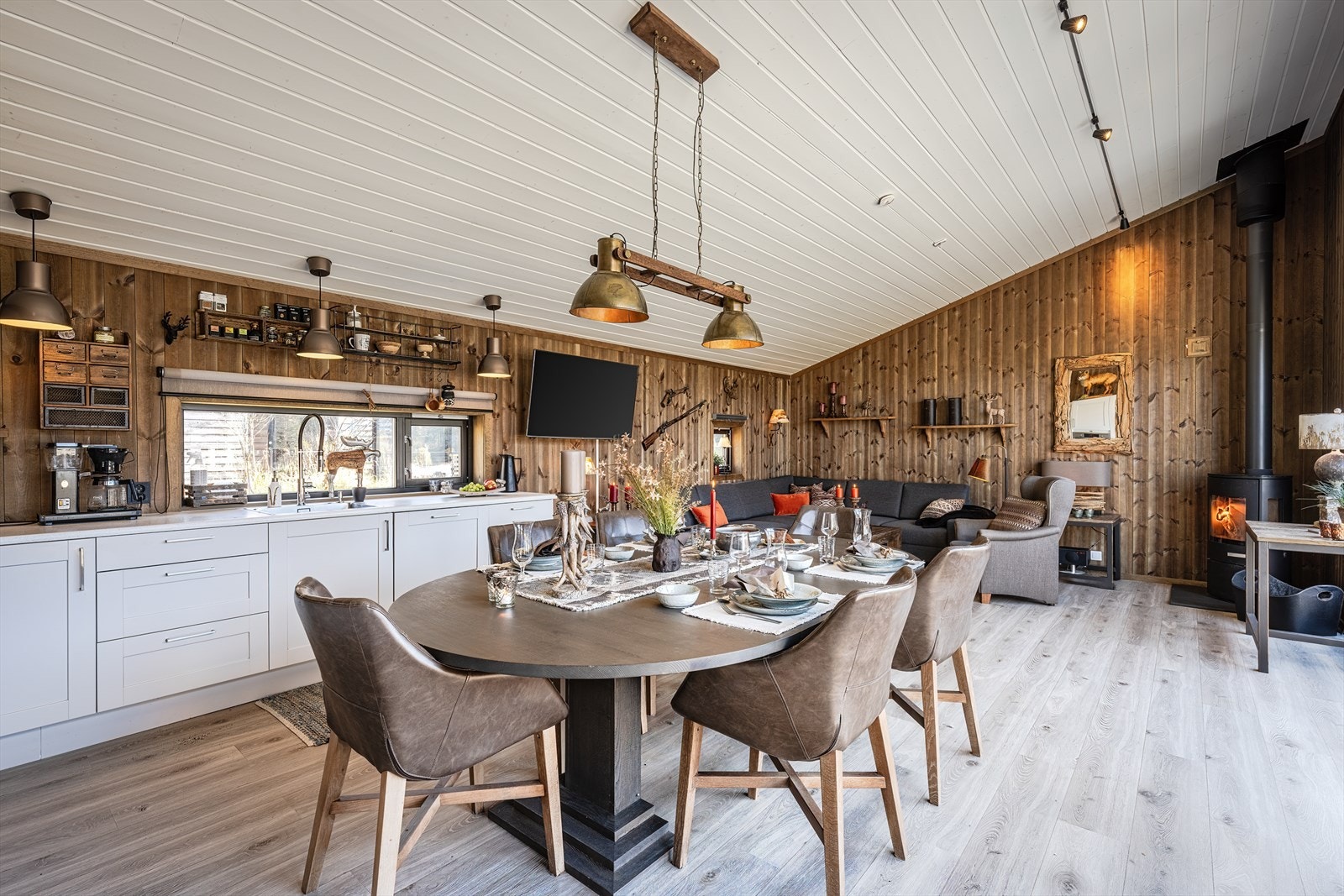 Oppholdsrommet har en god takhøyde og god plass for møblering av spisestue - og sofagruppe. Peis sentralt plassert. Galleribilde