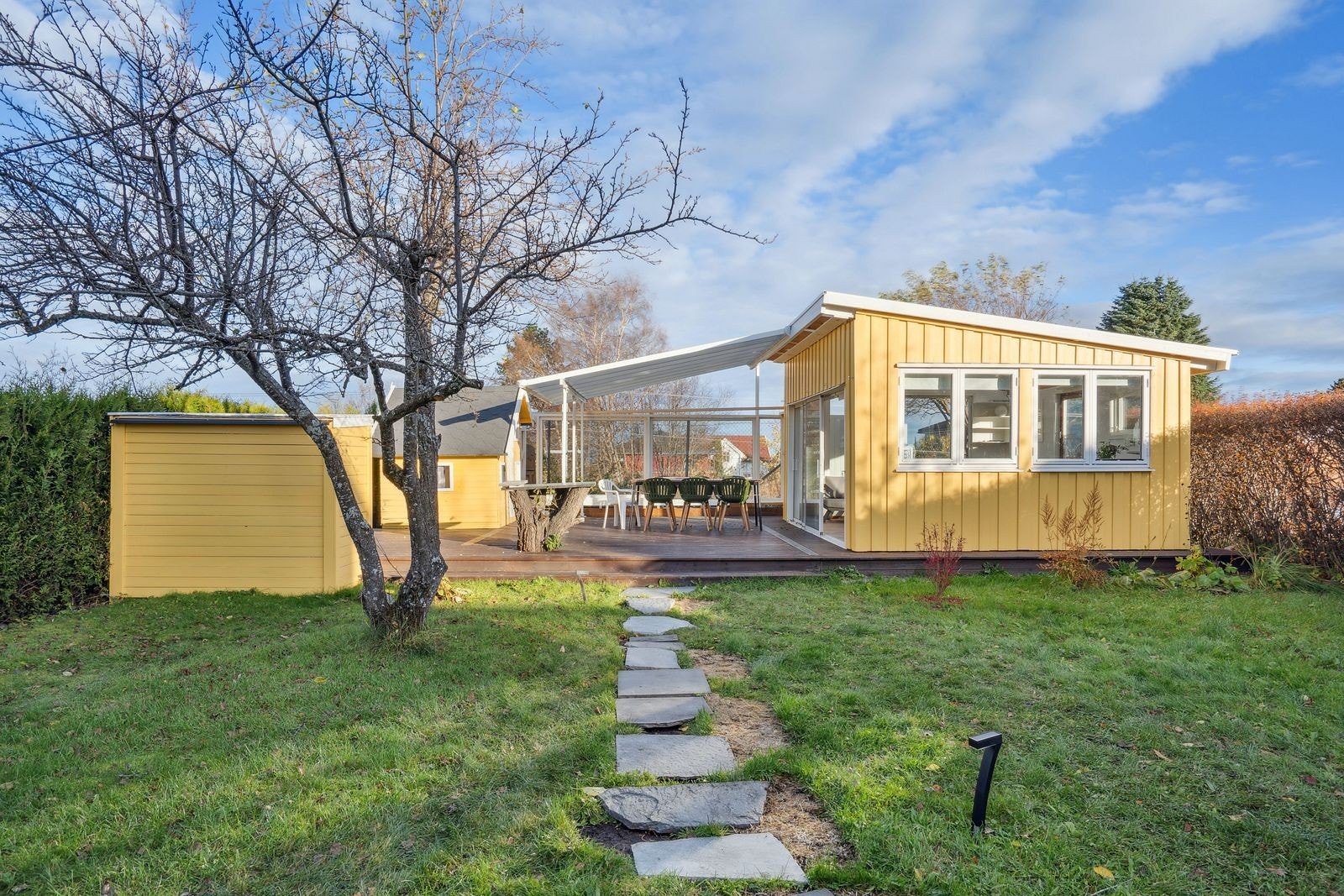 På baksiden av huset finner du en pent opparbeidet hage med stor terrase og en koselig utestue. Galleribilde