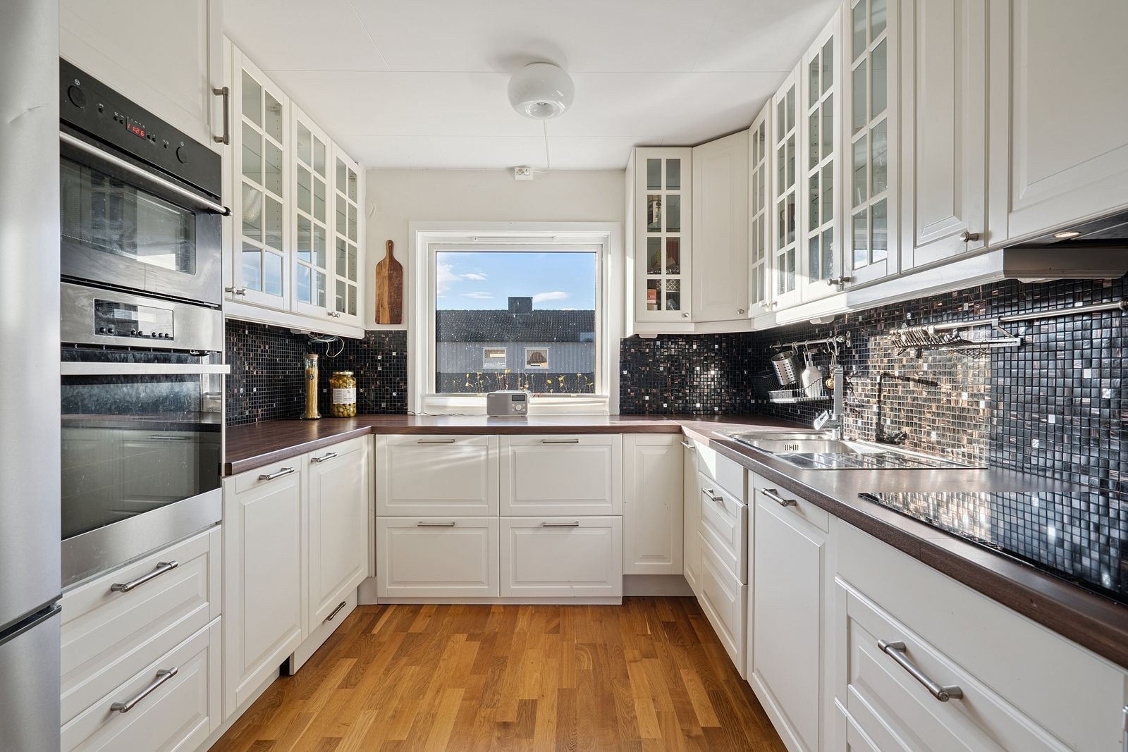 Pent kjøkken med mye skap- og benkeplass. Galleribilde