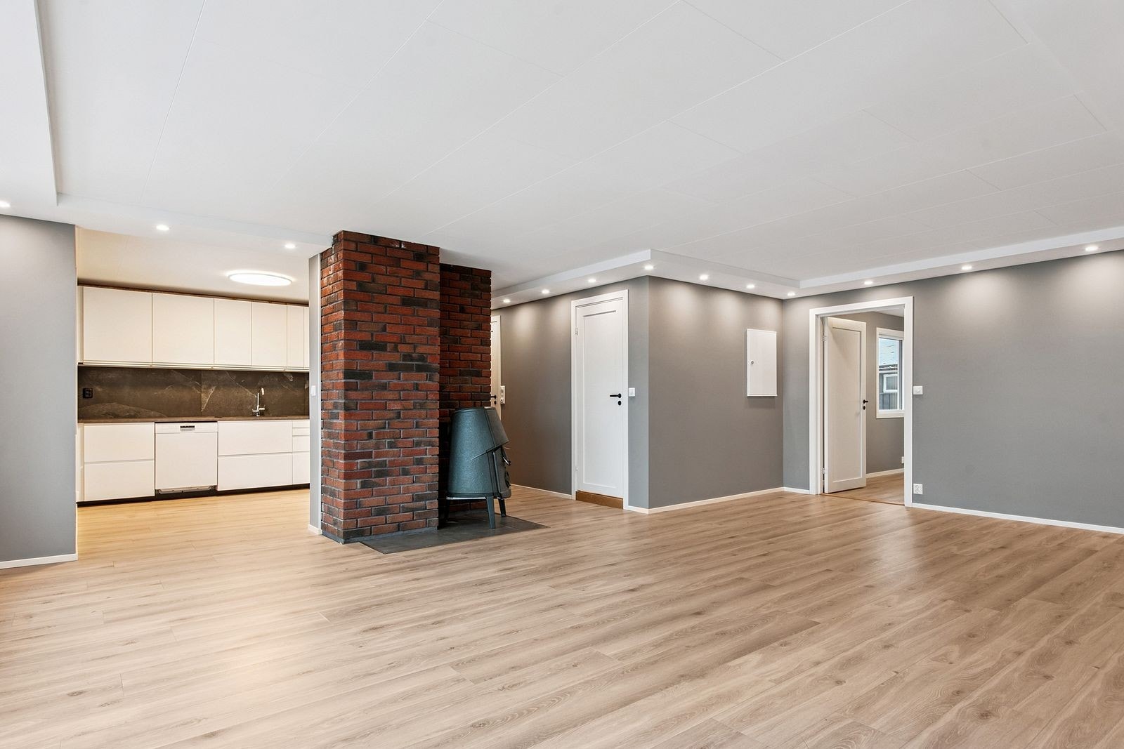 Stue og kjøkken i delvis åpen løsning. Peisen varmer godt på kalde dager Galleribilde