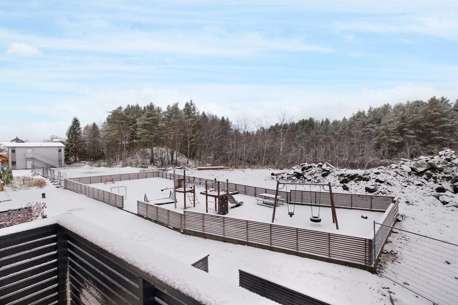 Utsikt mot lekeplass og skog gir en rolig atmosfære fra verandaen. Galleribilde