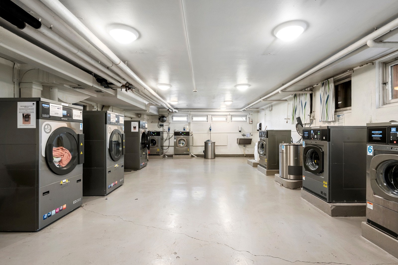 Praktisk fellesvaskeri med store industrimaskiner. Galleribilde