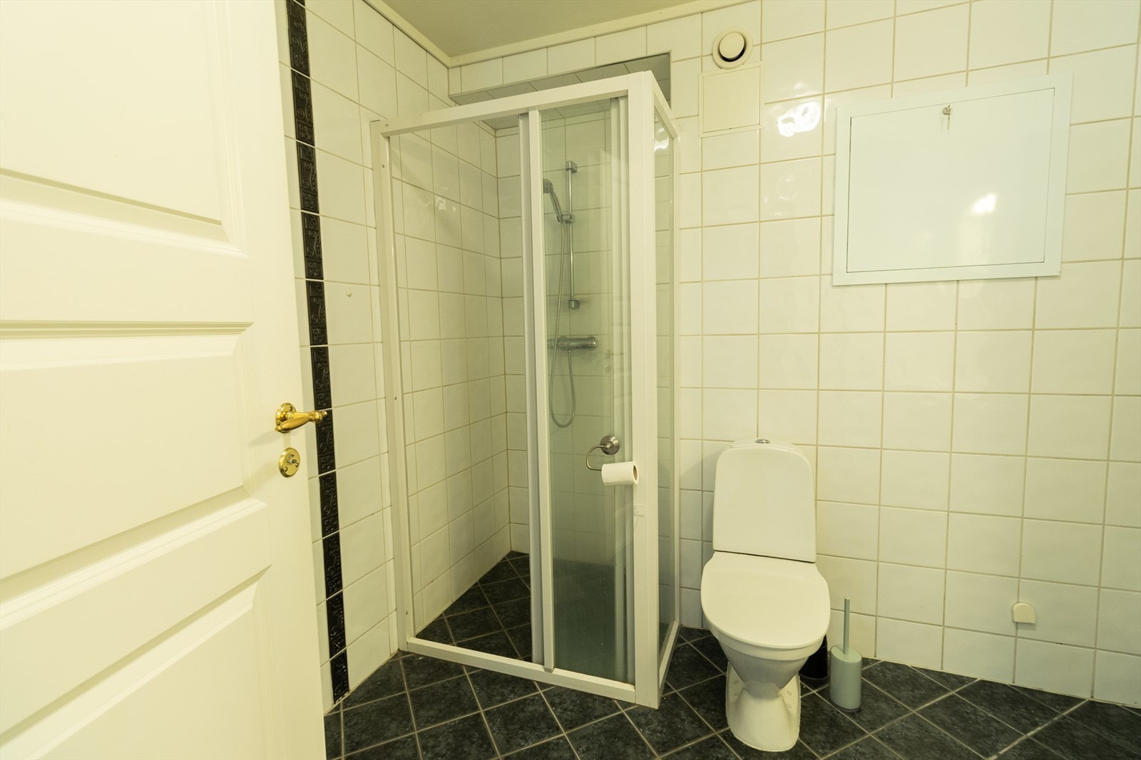 Badet har innredning med nedfelt servant, toalett, dusjvegger/hjørne og opplegg for vaskemaskin/tørketrommel Galleribilde