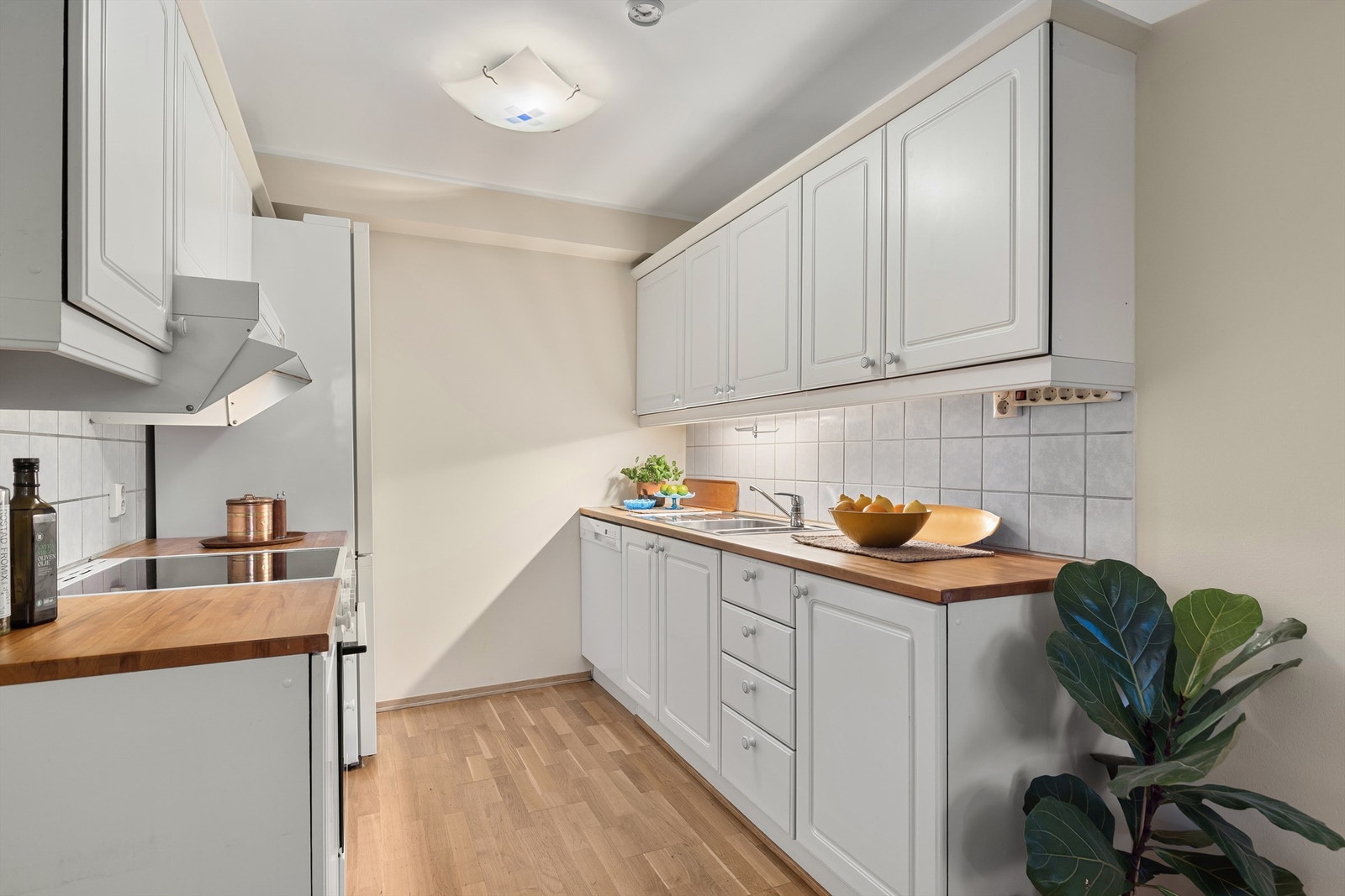 Lyst kjøkken med profilerte fronter og benkeplate i tre Galleribilde