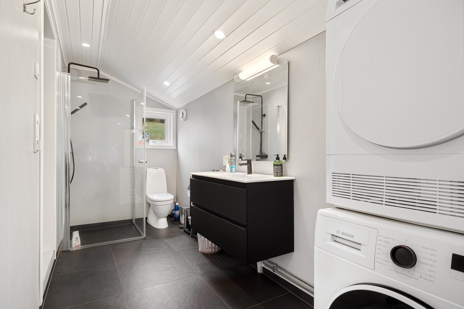 Nyere bad med fliser på gulv og baderomsplater på vegg Galleribilde