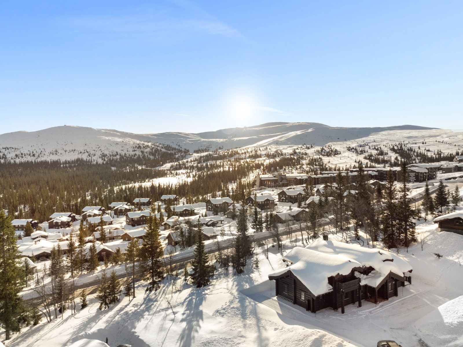 Bildet viser den vide horisonten med skog, fjell og alpinområdet i bakgrunnen. En utsikt som gir ro, lys og ekte fjellfølelse, perfekt etter en lang dag ute i løypene. Galleribilde