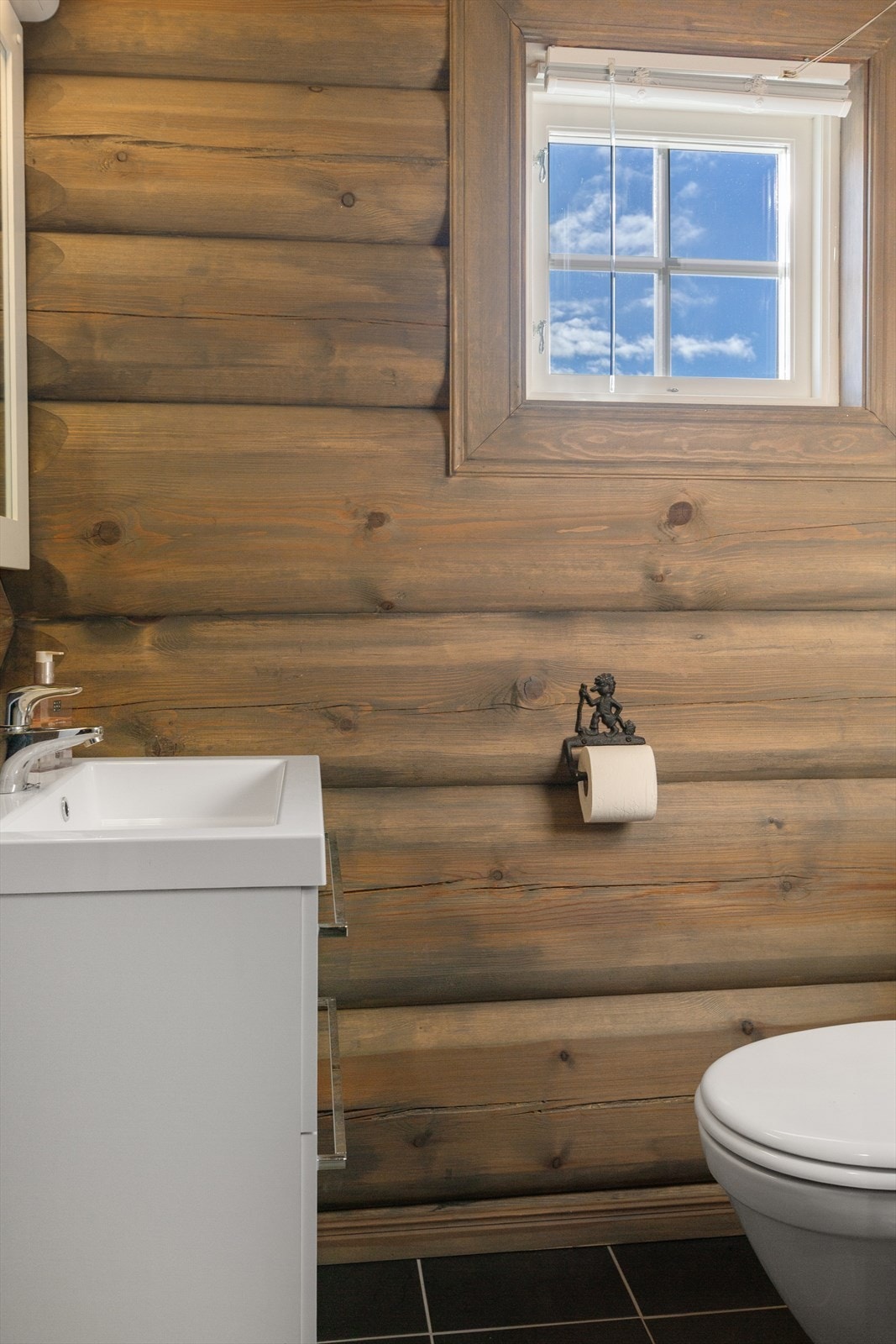 Eget praktisk toalettrom med montert klosett og servant, servantskap i underskap med speil og belysning. Galleribilde