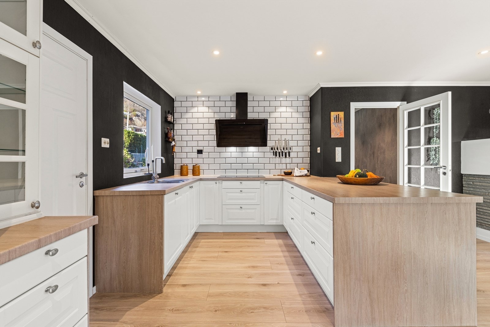 Tiltalende og velutstyrt kjøkken, innredning med profilerte fronter. Benkeplaten er av laminat. Kjøkkenventilator med avtrekk ut. Galleribilde