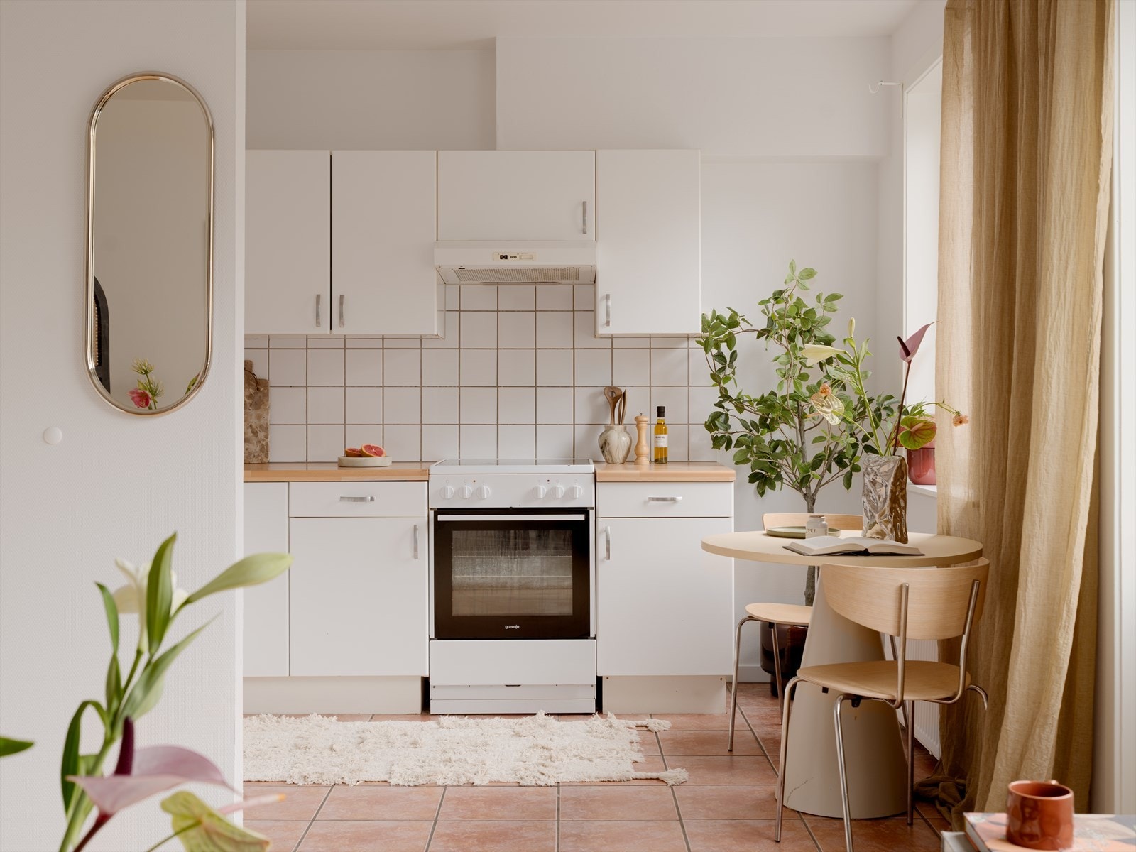 Lyst kjøkken med fliser på gulv og bakvegg. Galleribilde