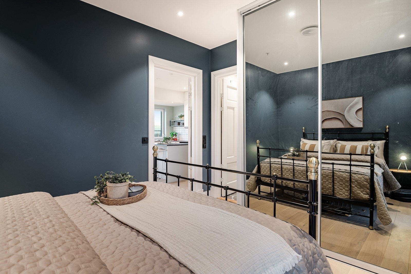 Rommet har plass til dobbeltseng med tilhørende nattbord. Det er montert en praktisk skyvedørsgarderobe med speilfronter. Galleribilde