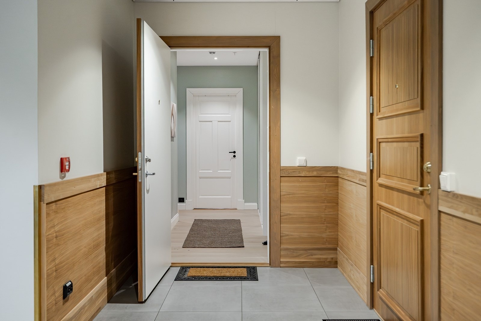 Bygget og leiligheten holder en høy standard med fokus på detaljer. Felles gang med flislagt gulv og stilfull brystning med trepaneler gir en innbydende adgang til leiligheten. Galleribilde