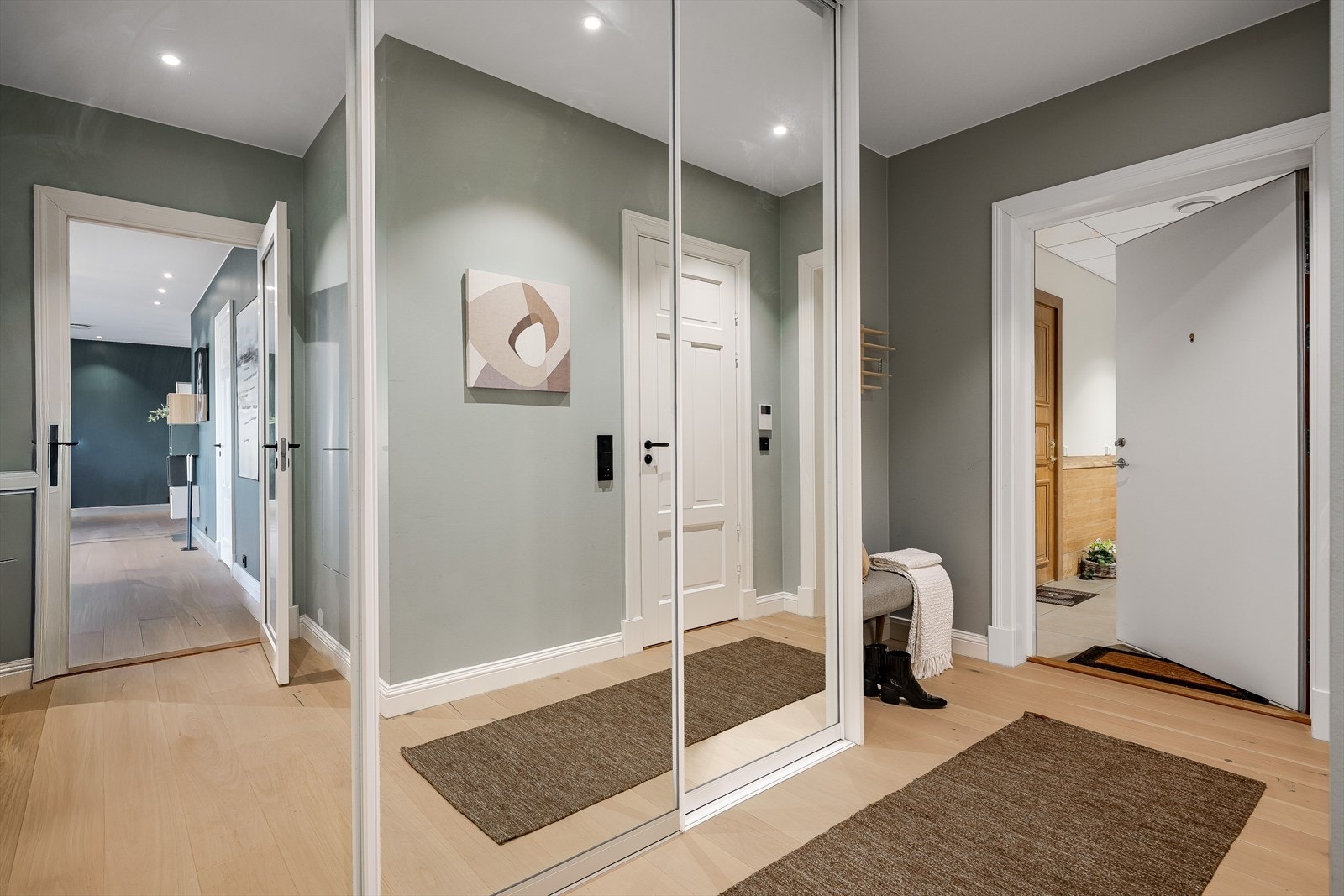 Leiligheten har en romslig entré med skyvedørsgarderobe med speilfornter. Galleribilde