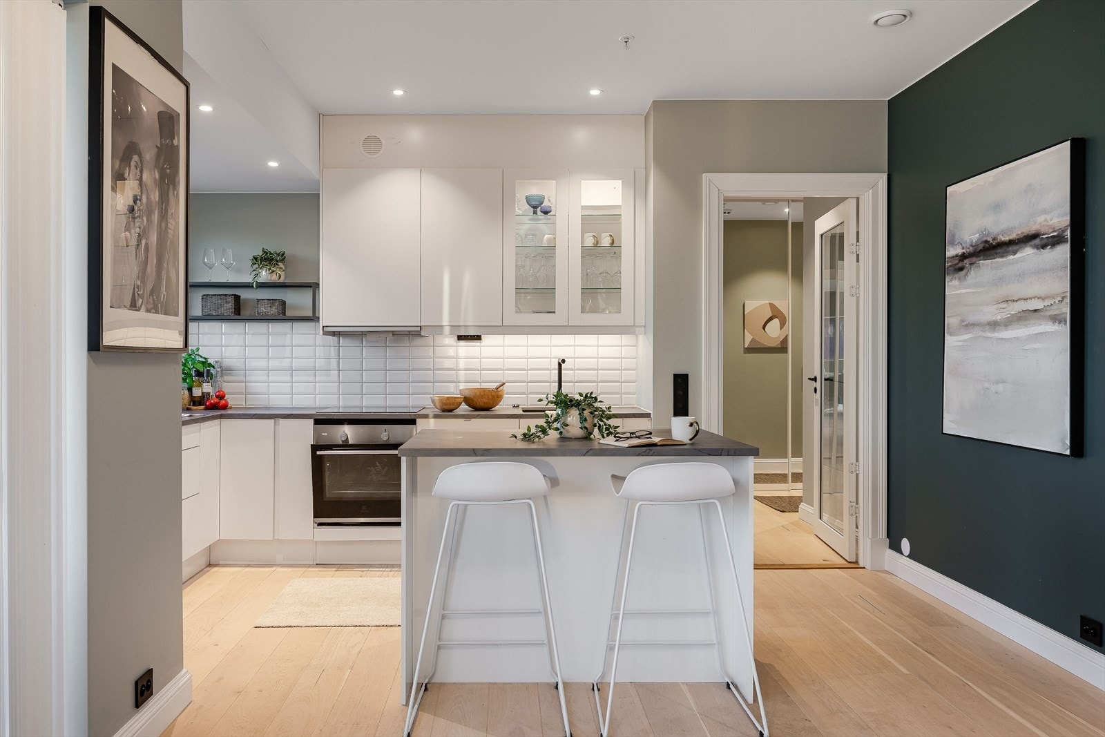 Fra gangen kommer du først inn i kjøkkenet som er lyst og delikat. Det har innredning fra Norema med hvite , glatte fronter og laminert benkeplate. Galleribilde