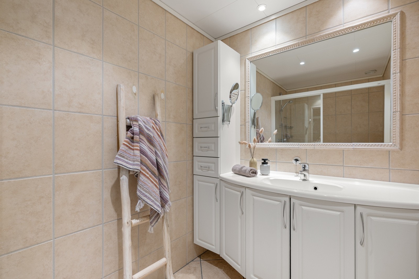 Badet har fliser på både gulv og vegger, varmekabler, servant og dusjhjørne. Galleribilde