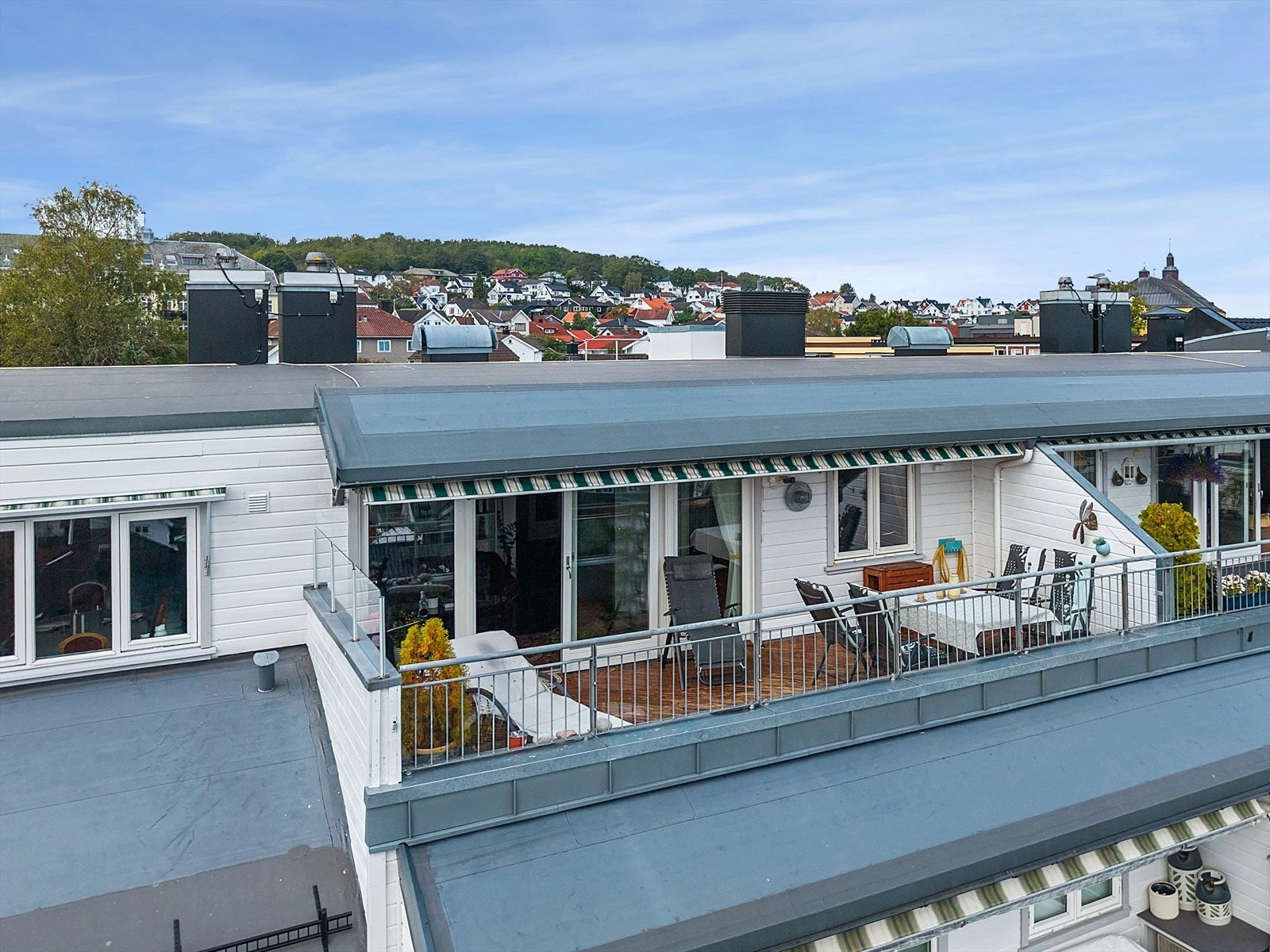 Romslig takterrasse med formiddagssol og stor markise. Galleribilde