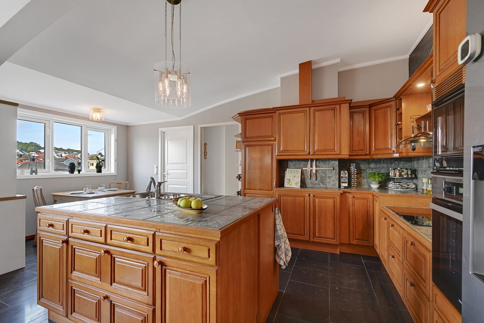 Skråtak også på kjøkken, hvor det er spiseplass og grovkjøkken/vaskerom bak dør. Galleribilde