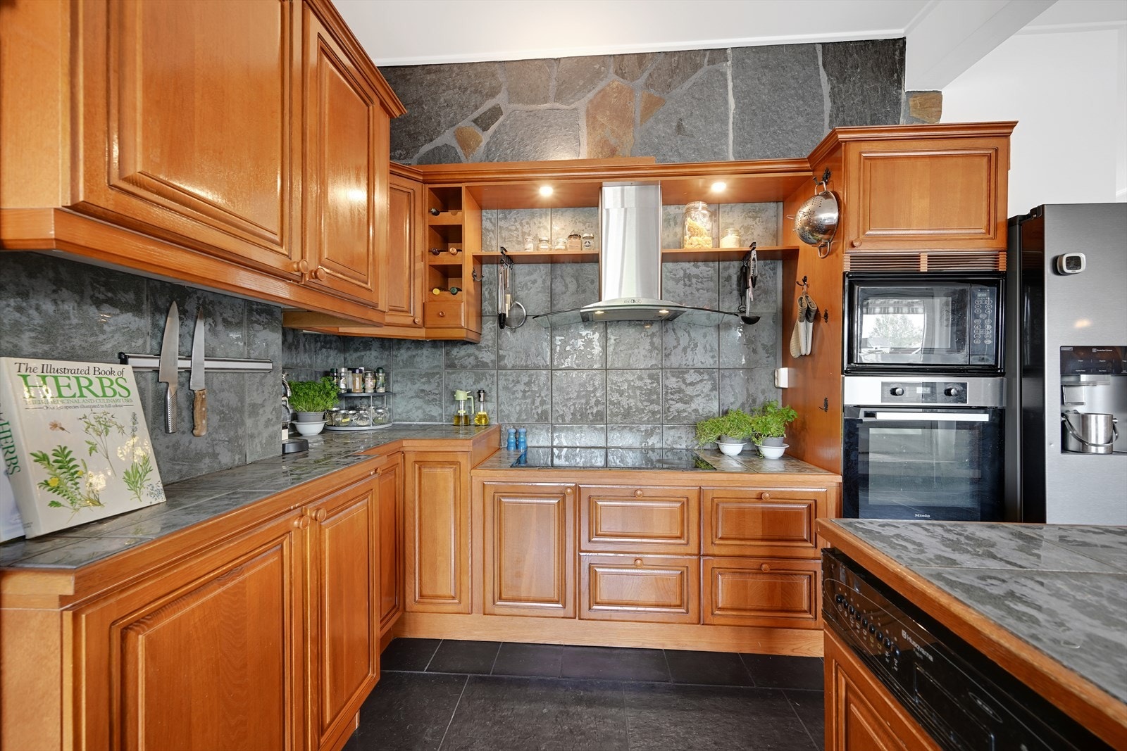 Nyere bred induksjonstopp, stekeovn, eldre mikro og oppvaskmaskin, integrert kjøleskap og løst side-by-side kjøl/frys medfølger. Galleribilde