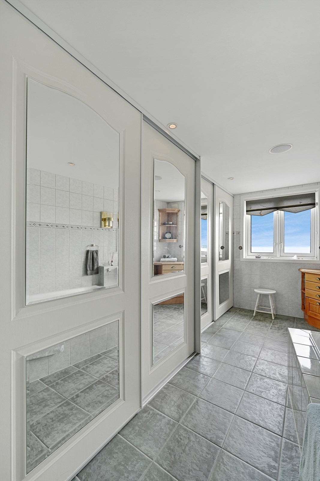 Bad med skyvedørsgarderobe gir godt med oppbevaring. Galleribilde