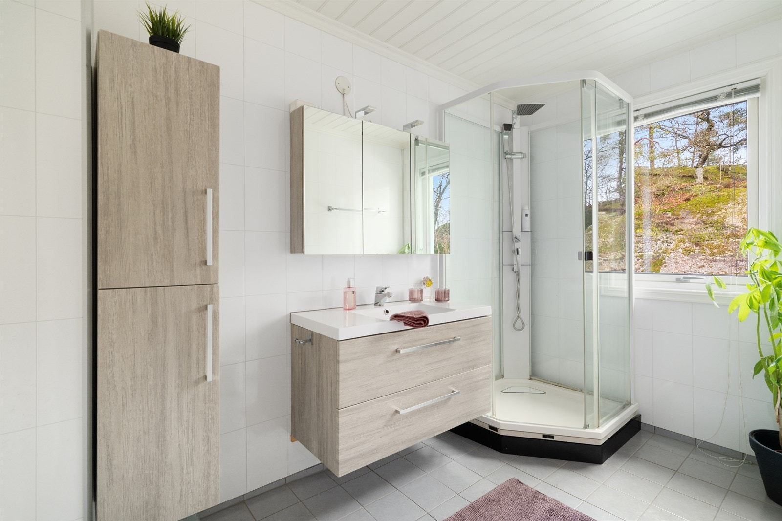 Badet fra 2013 har flislagt gulv med varmekabler og moderne innredning med dype skuffer og heldekkende servant. Ytterligere oppbevaringsplass i speilskap og høyskap. Badet er også innredet med dusjkabinett. Galleribilde