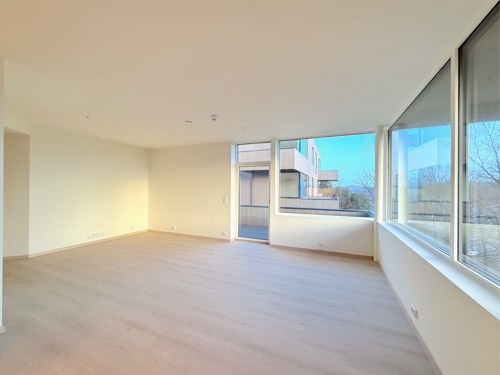 Lys stue med store vinduer og utgang til balkong. Galleribilde