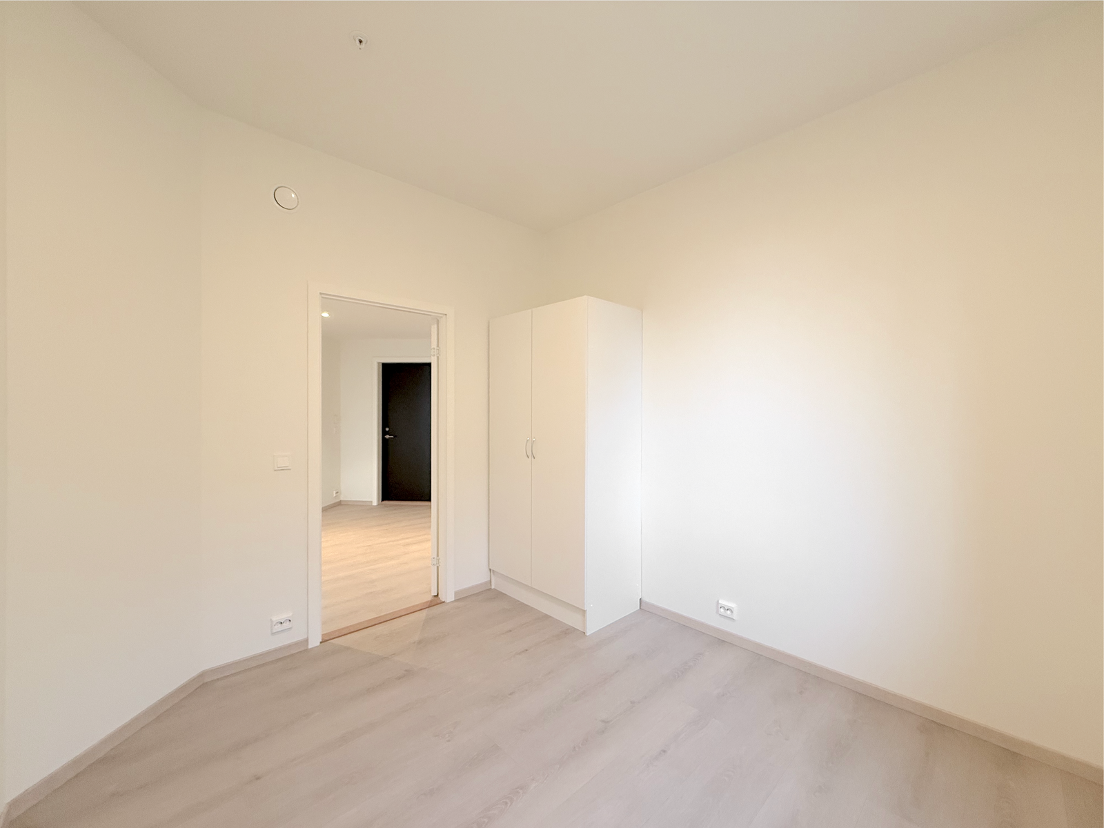 Pent soverom med garderobeskap og lyse overflater. Galleribilde