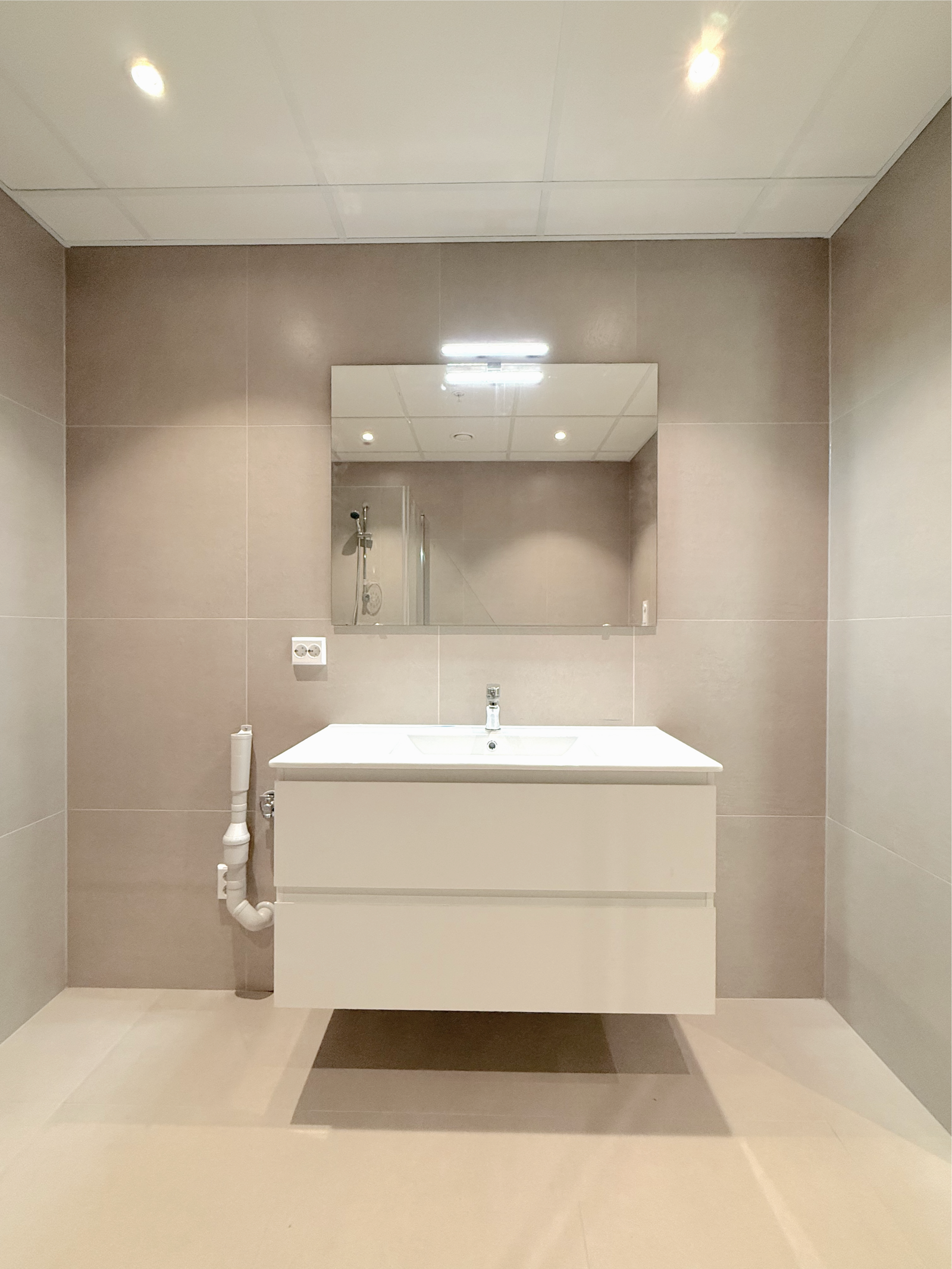 Baderommet har moderne innredning og stort speil. Galleribilde