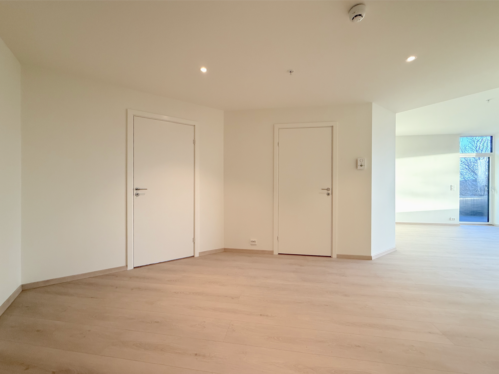 Luftig hall med flere dører til soverom og åpning mot stuen. Galleribilde