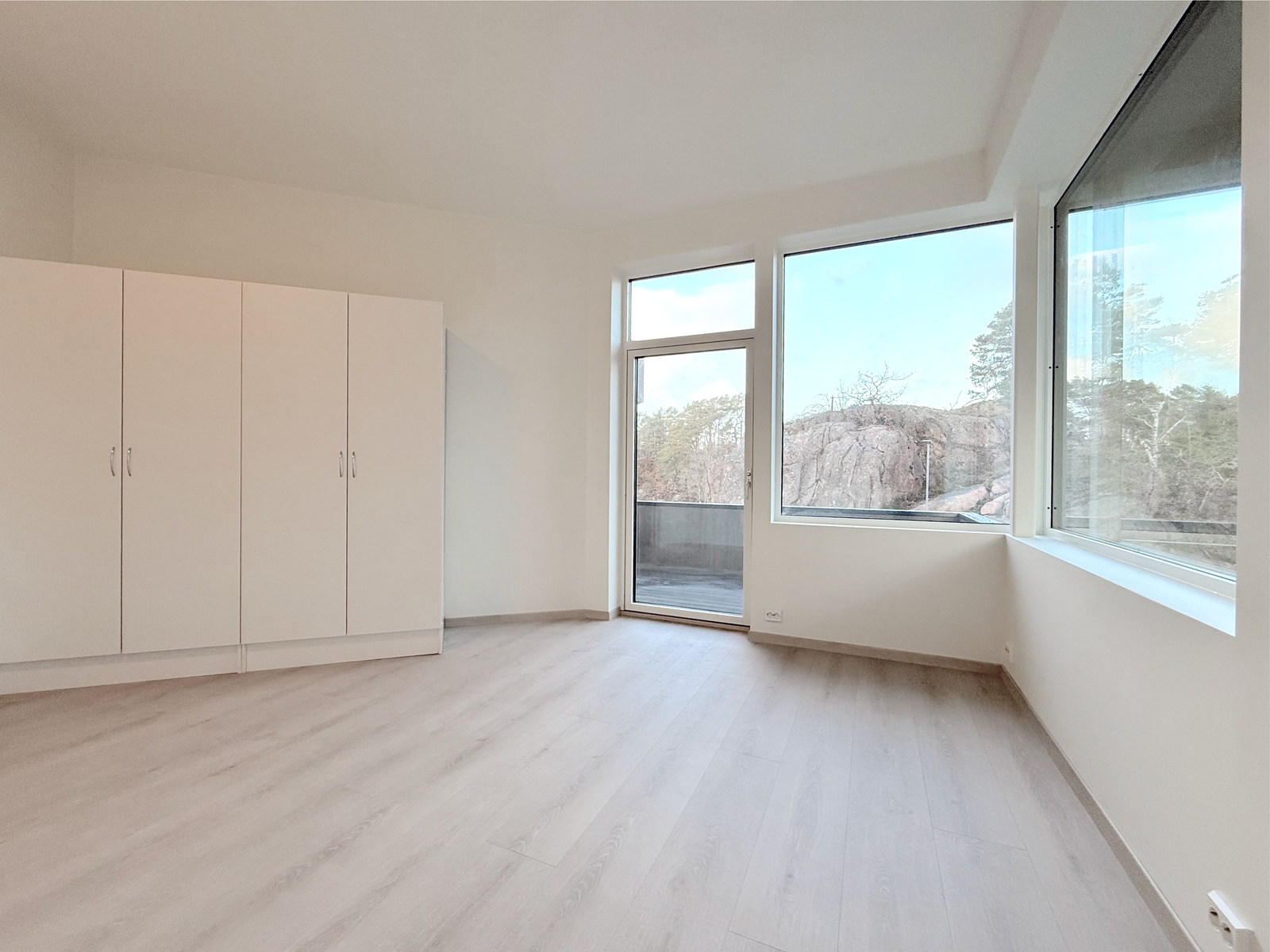 Romslig hovedsoverom med store vinduer og garderobeskap. Galleribilde