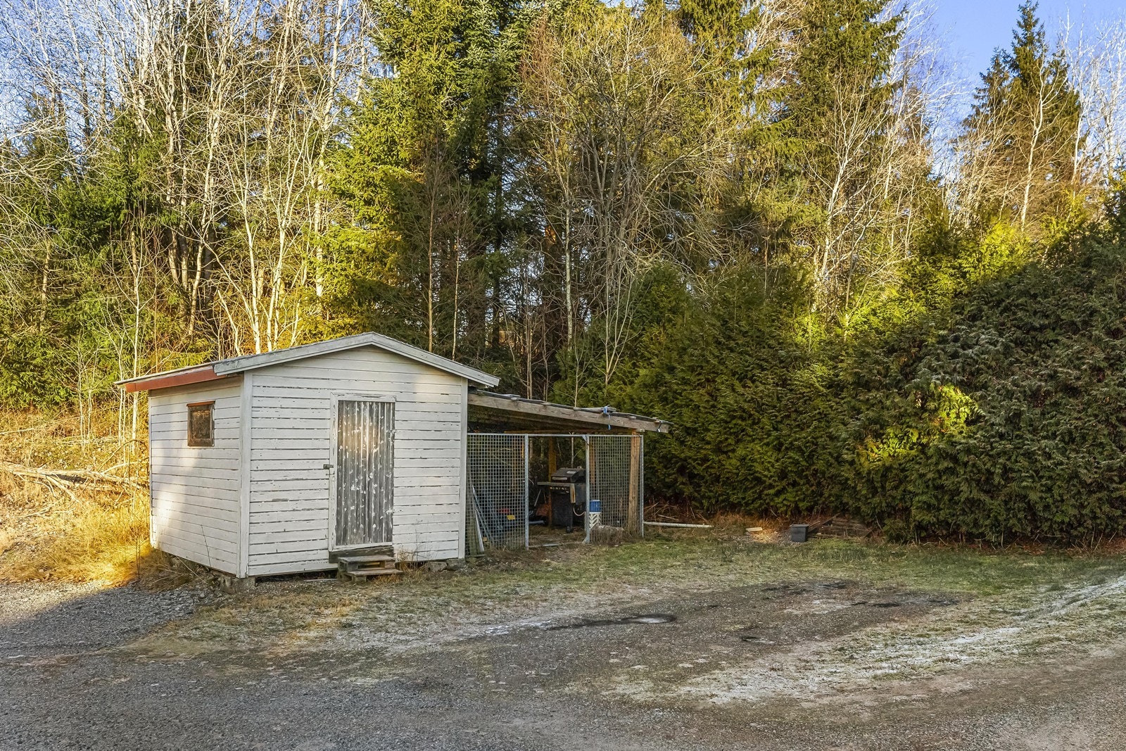 Redskapsbod med trekonstruksjoner og asfaltpappshingel på taket gir praktisk oppbevaring. Galleribilde