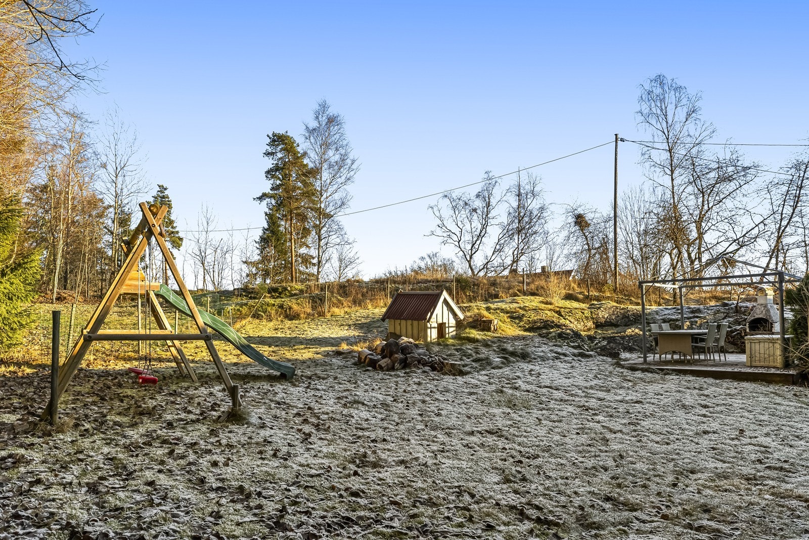 Tomten består av gressplen og gruset gårdsplass, ideelt for lek og opphold. Galleribilde