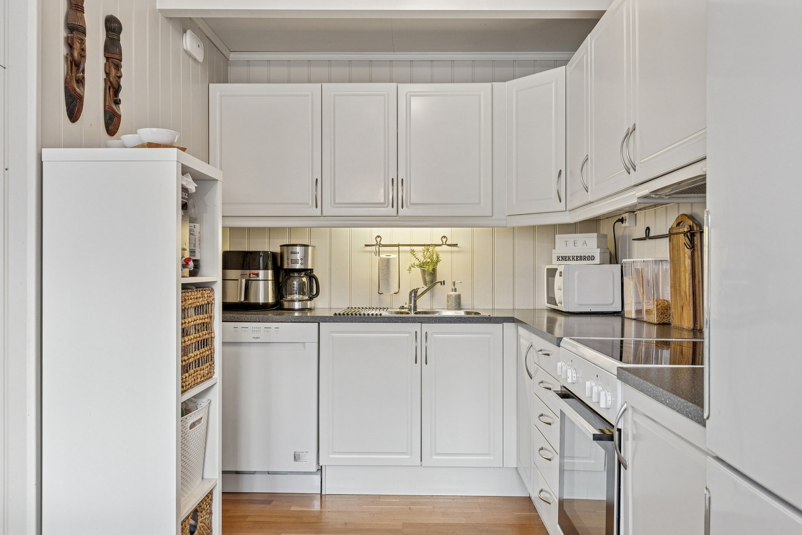 Kjøkkenet har en tidløs innredning med profilerte fronter, laminert benkeplate og rikelig med oppbevaringsplass i både benkeskap og overskap. Frittstående komfyr med keramisk platetopp samt en vegghengt ventilator bidrar til god ventilasjon under matlagin Galleribilde