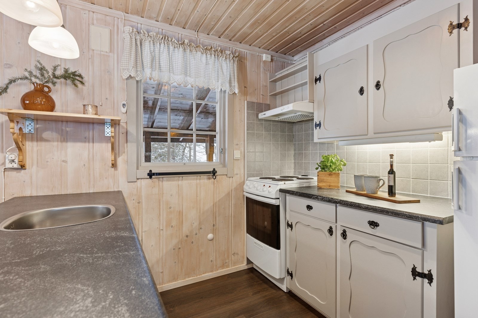 Praktisk og pent kjøkken med komfyr og kjøleskap. Galleribilde