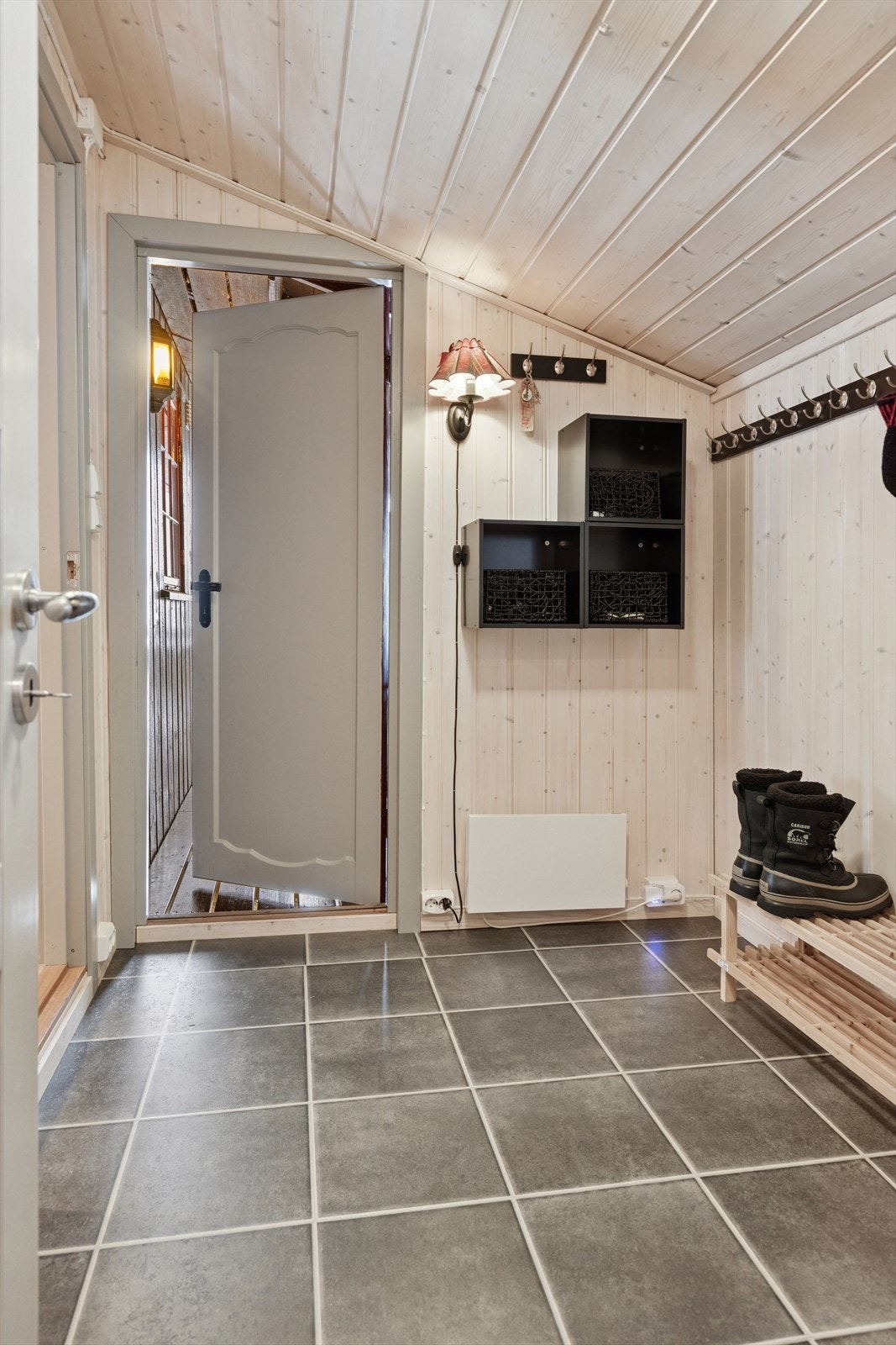 Romslig entré med flislagt gulv. Galleribilde