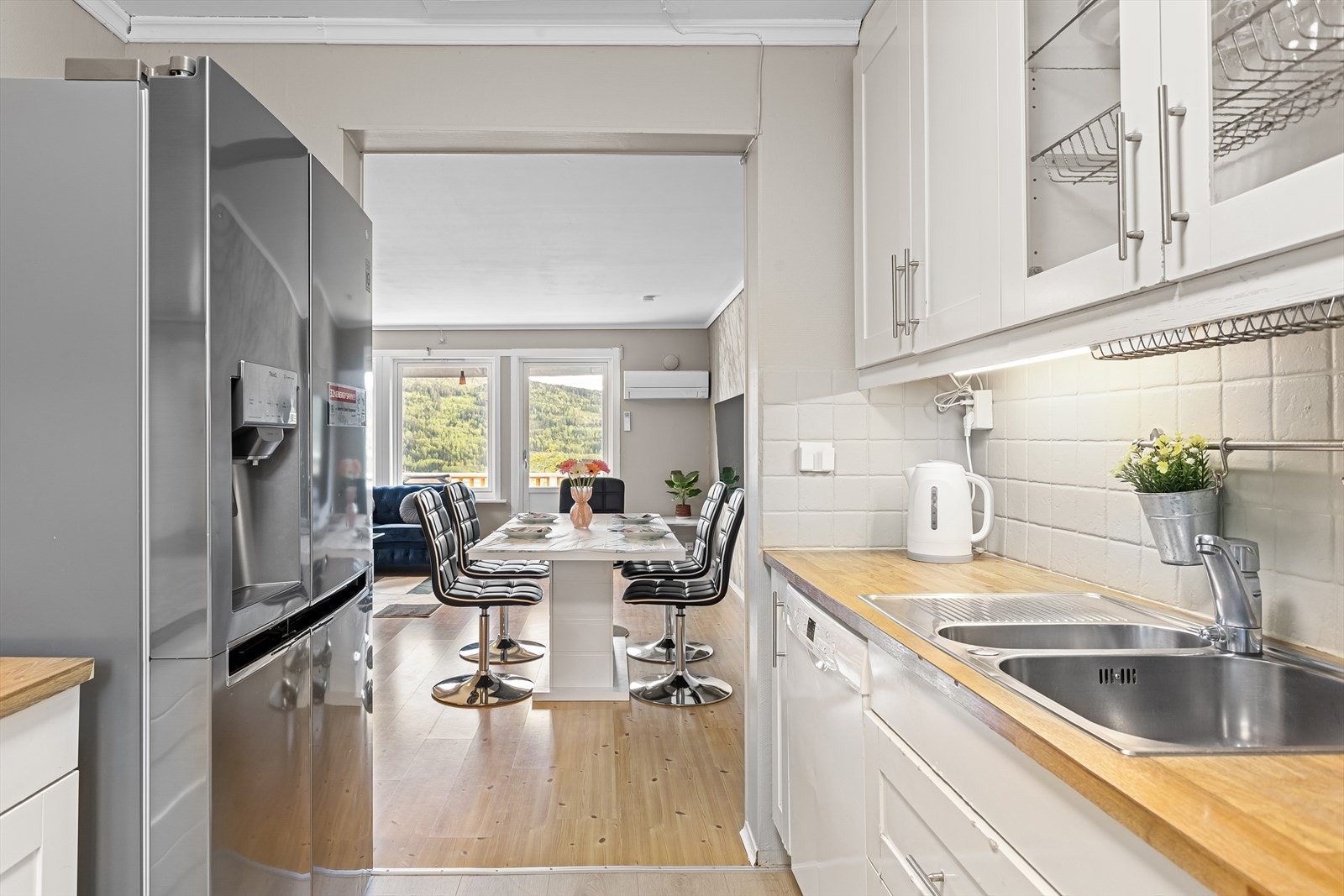 Klassisk kjøkkeninnredning med hvite profilerte fronter og benkeplate av laminat. Galleribilde