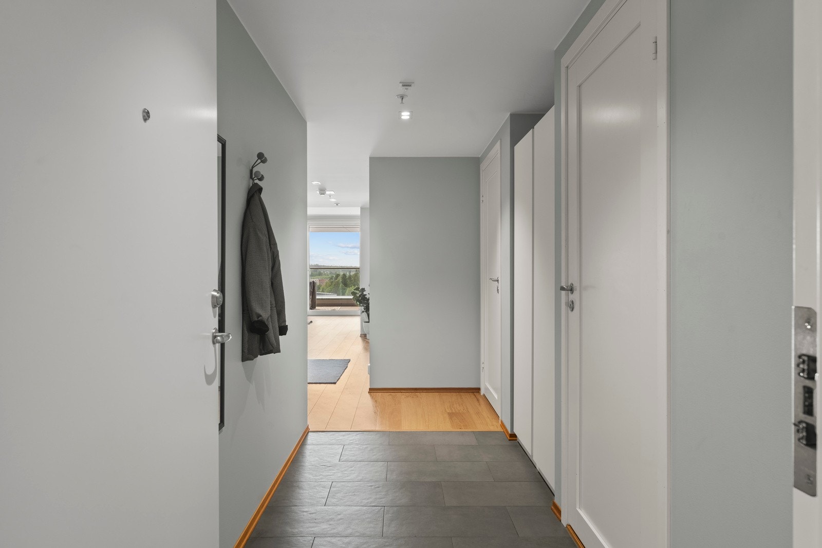 Lys og romslig entré med god plass til oppbevaring av sko og yttertøy - et innbydende førsteinntrykk av boligen. Galleribilde