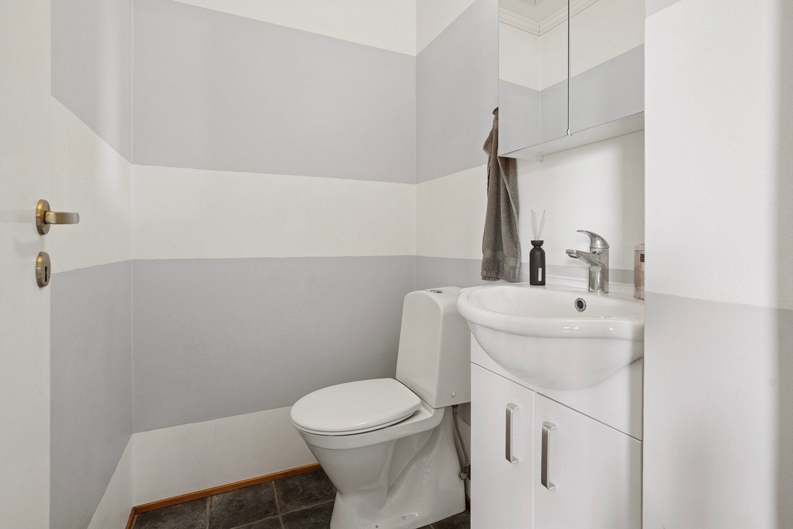 Separat wc-rom med gulvstående wc og lys baderomsinnredning. Rommet ligger i tilknytning til gang. Galleribilde