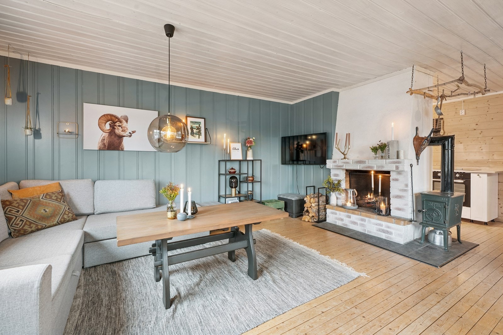 Lys og hyggelig stue malt i tidsriktige farger. I stuen er det en plassmurt, åpen peis, med tilhørende vedovn. Vedovnen varmer godt på kalde høstdager. Galleribilde