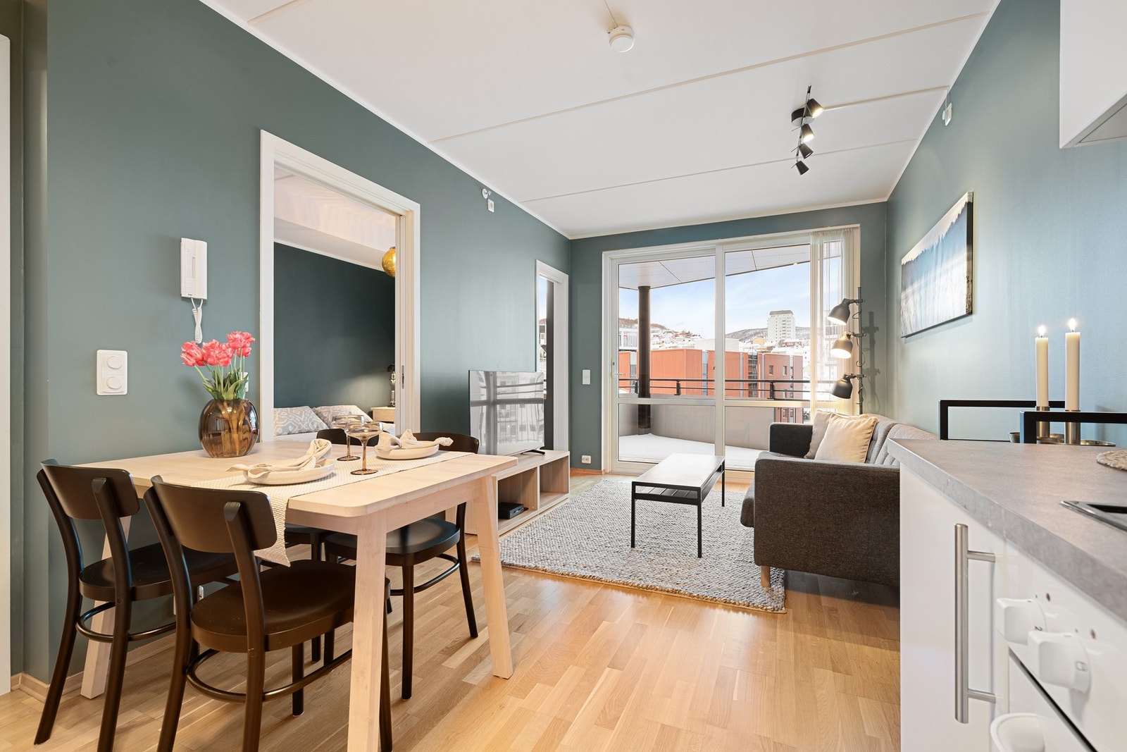 Stor skyvedør fra stua ut til balkong gir verdifullt lysinnslipp inn Galleribilde