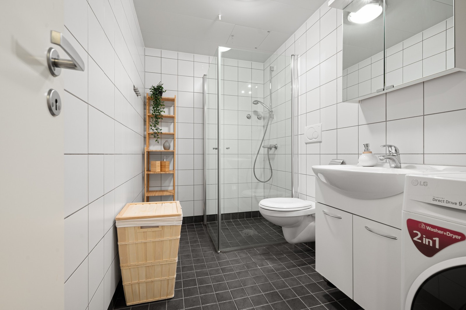 Rommet inneholder vegghengt toalett og baderomsinnredning, dusjhjørne og røropplegg til vaskemaskin Galleribilde