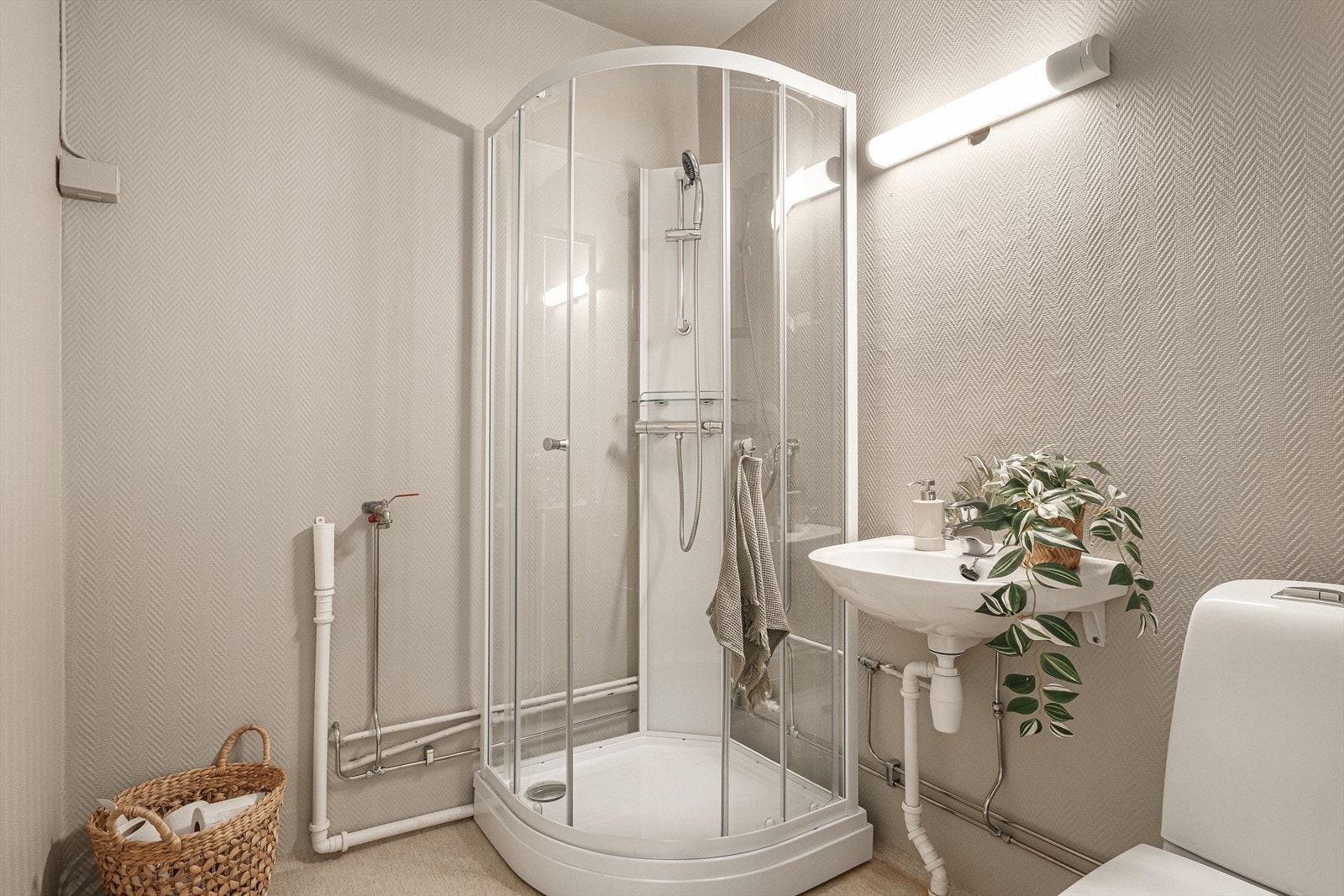 Bad med dusjkabinett, servant og toalett. Opplegg for vaskemaskin. Galleribilde