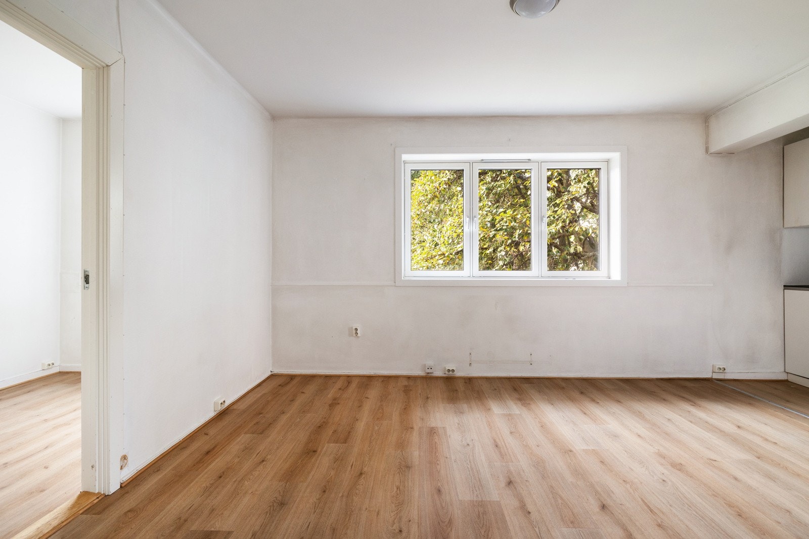 Leiligheten har en romslig stue med et vindu som slipper inn naturlig lys Galleribilde