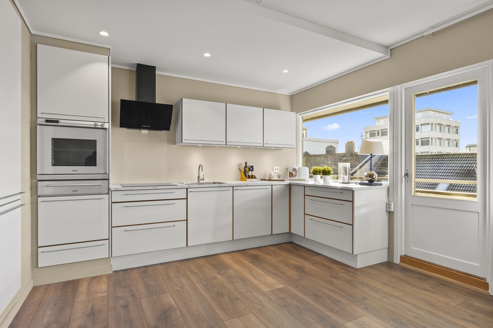 Lys og flott kjøkkeninnredning med integrerte hvitevarer. Det er montert glassplate i sprutsone bak vask og platetopp (montert etter foto) Galleribilde