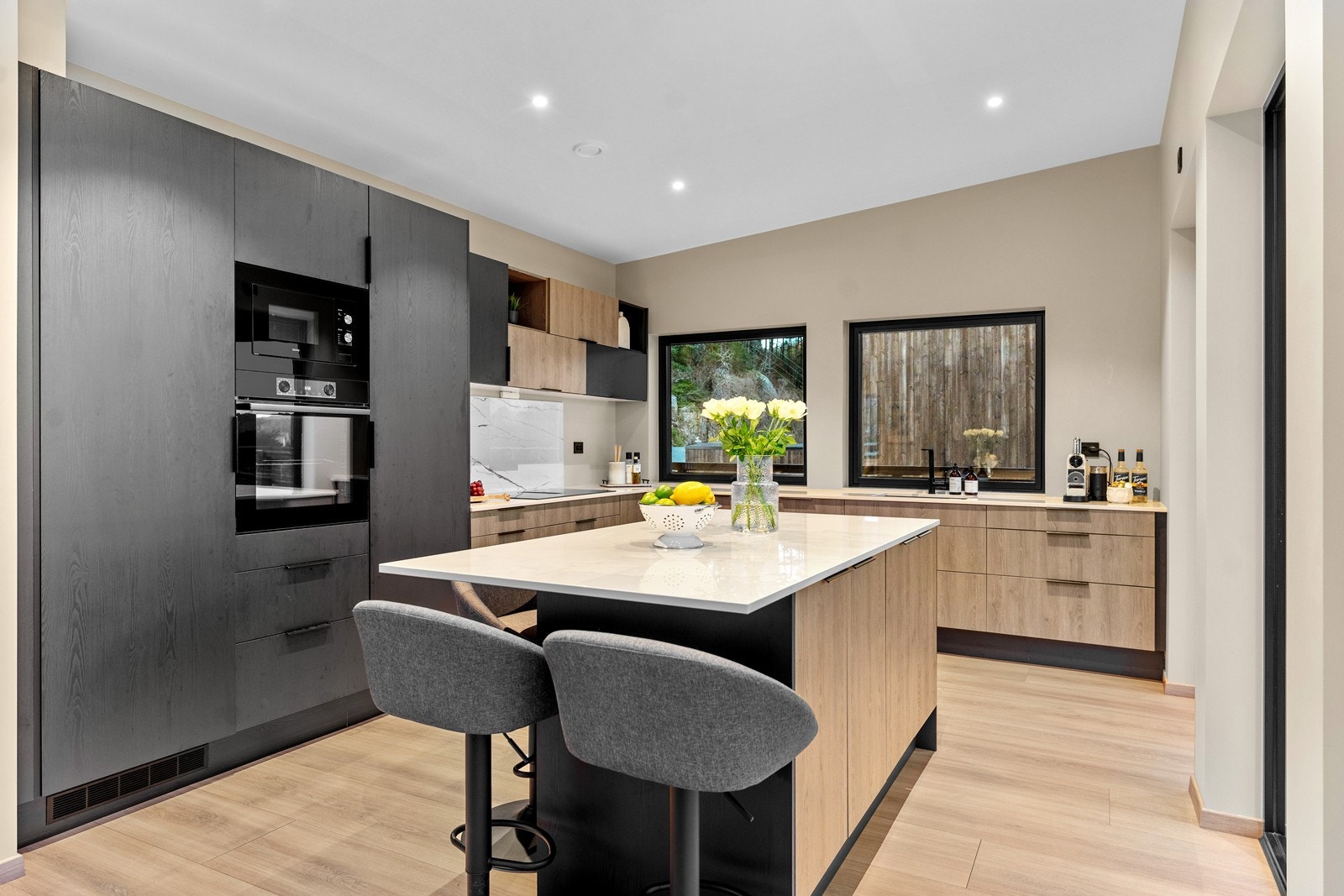 Integrerte hvitevarer og praktisk kjøkkenøy med oppbevaringsplass. Galleribilde