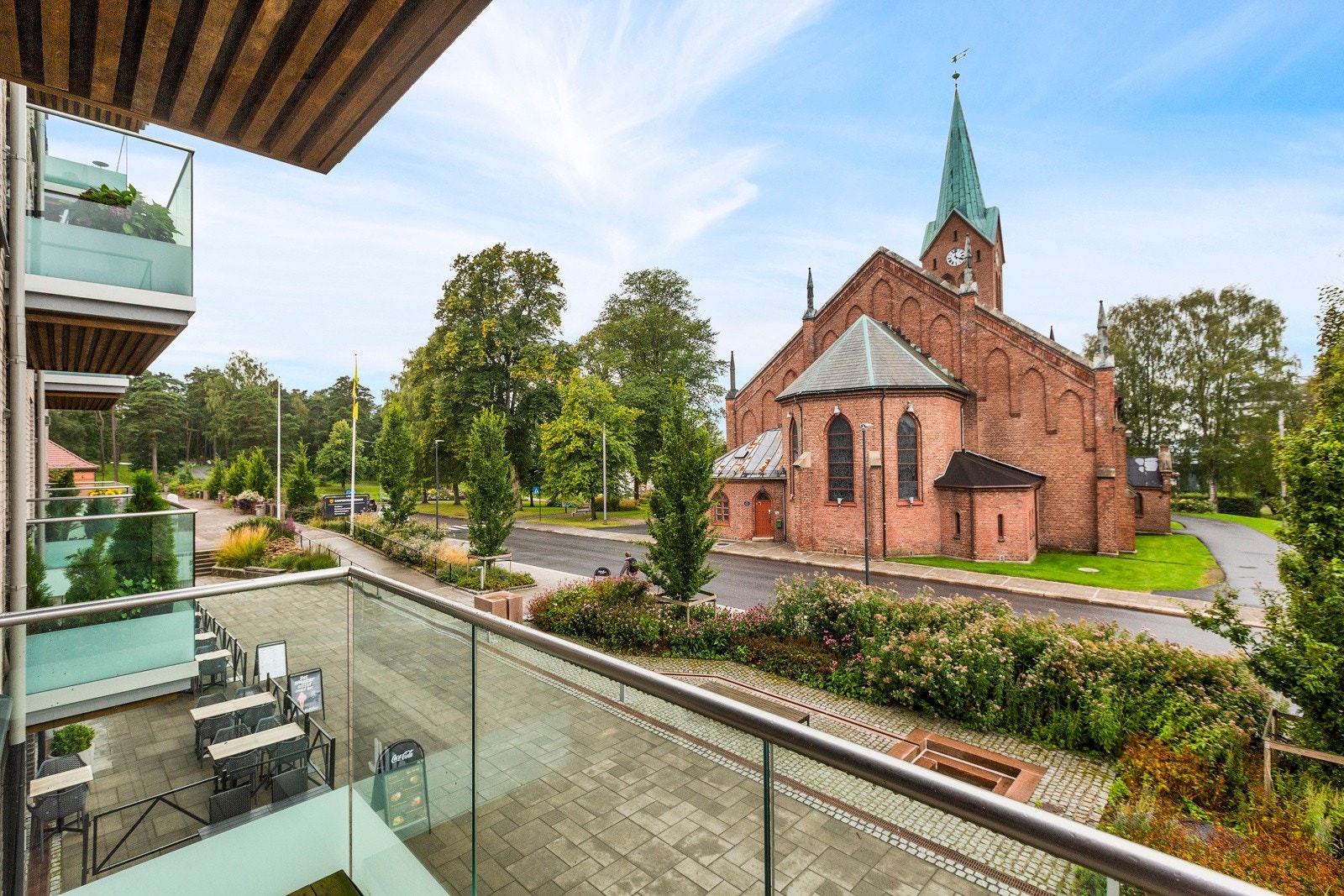 Stor veranda med utsikt mot kirken og kirkeparken Galleribilde