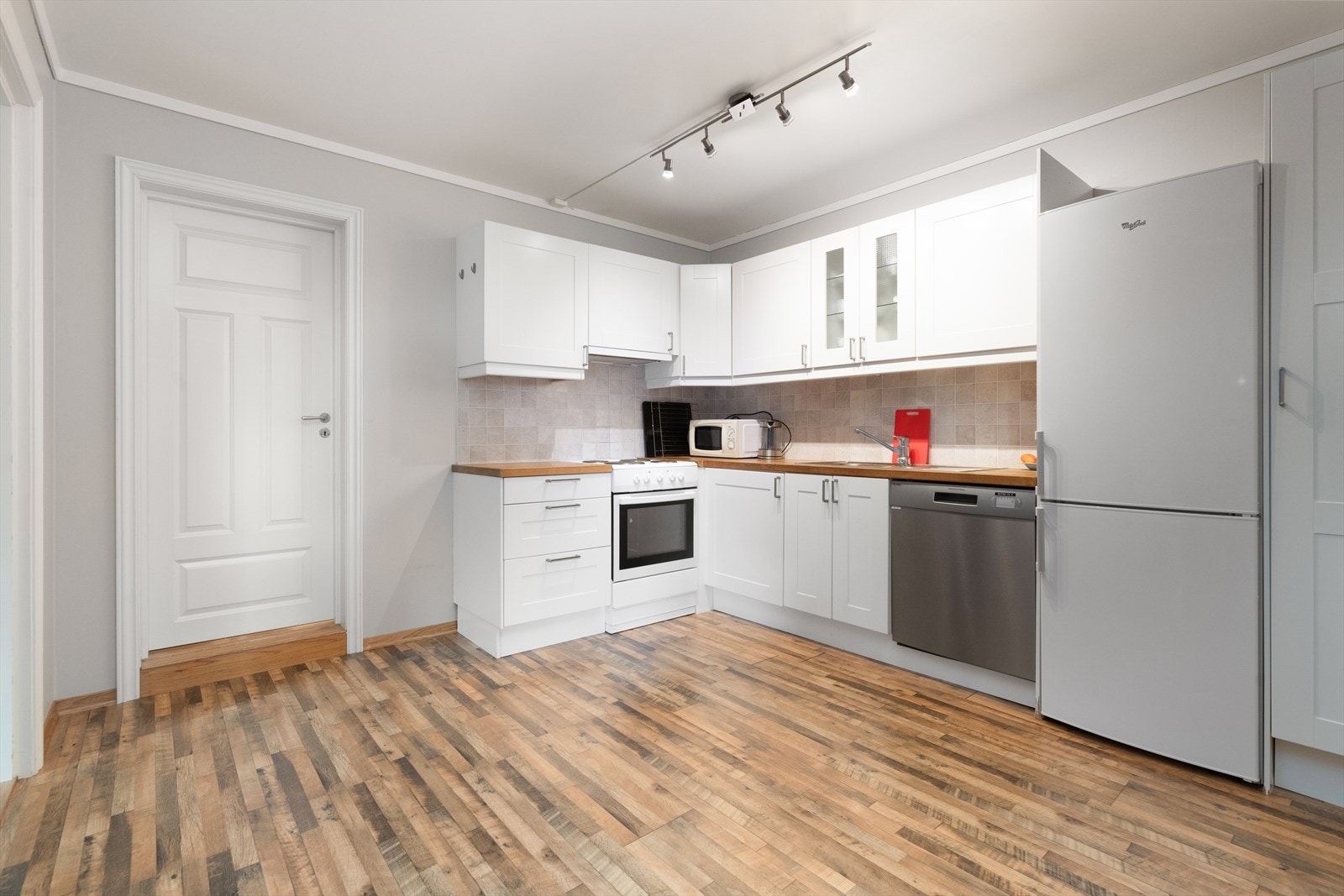 Kjøkken har innredning med profilerte fronter og benkeplate i heltre med flis over. Over stekesone er det ventilator med kullfilter. Galleribilde