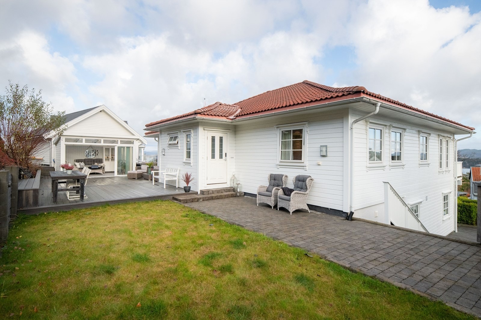 Romslig uteområde på øverste plan med belegningsstein, terrasseplatting og utestue. Galleribilde