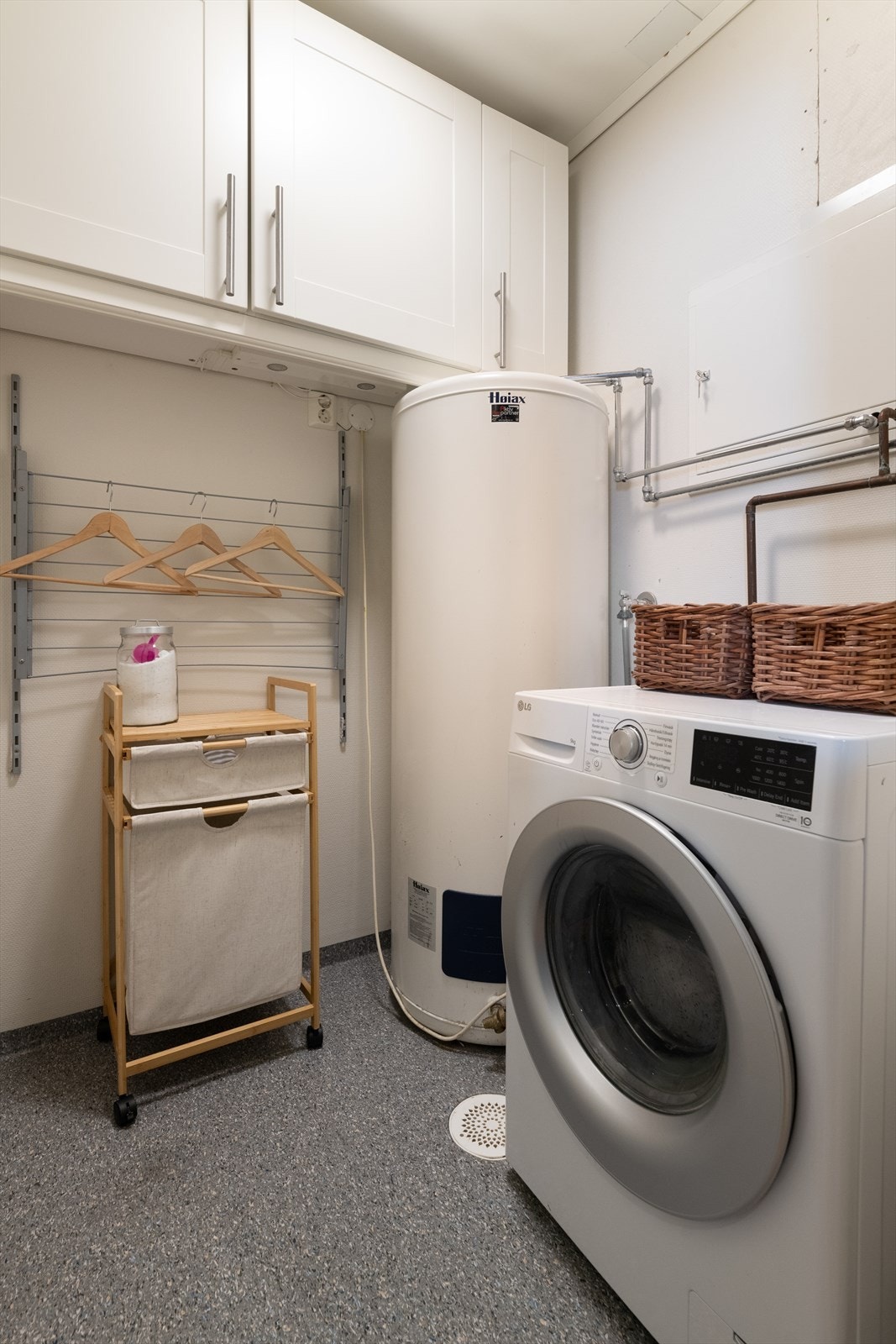 Vaskerommet innehar skap, opplegg for vaskemaskin og varmtvannstank. Galleribilde