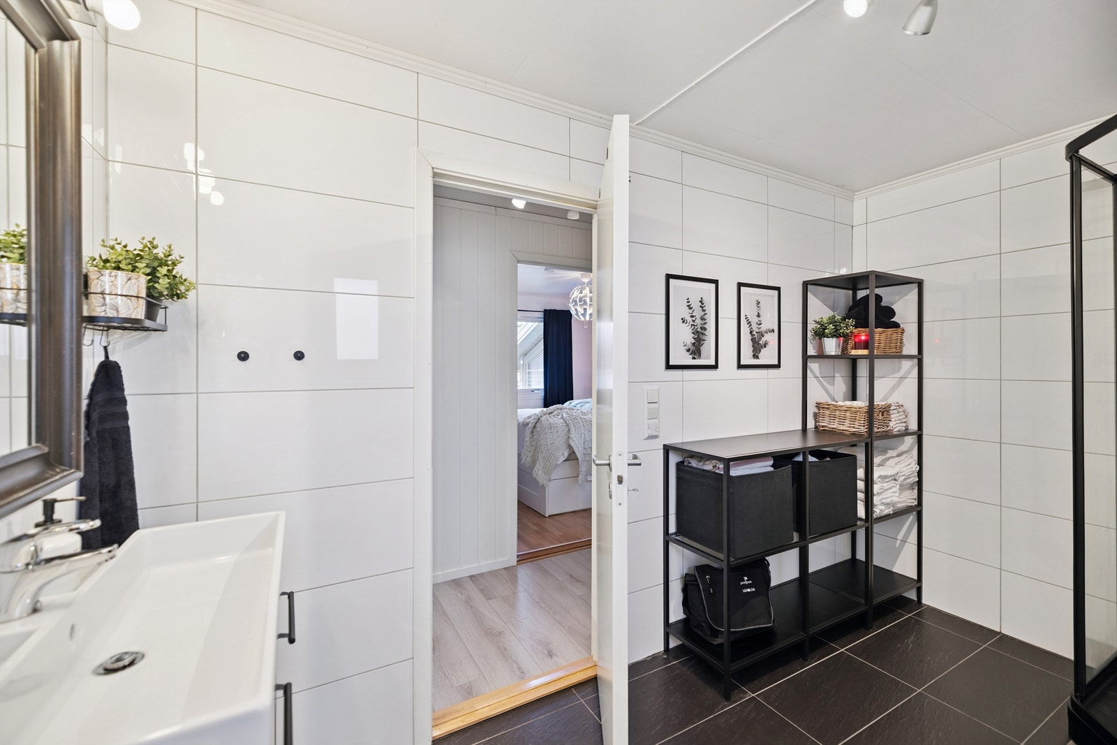 Badet har flislagte overflater, elektrisk gulvvarme og servant i innredning. Galleribilde