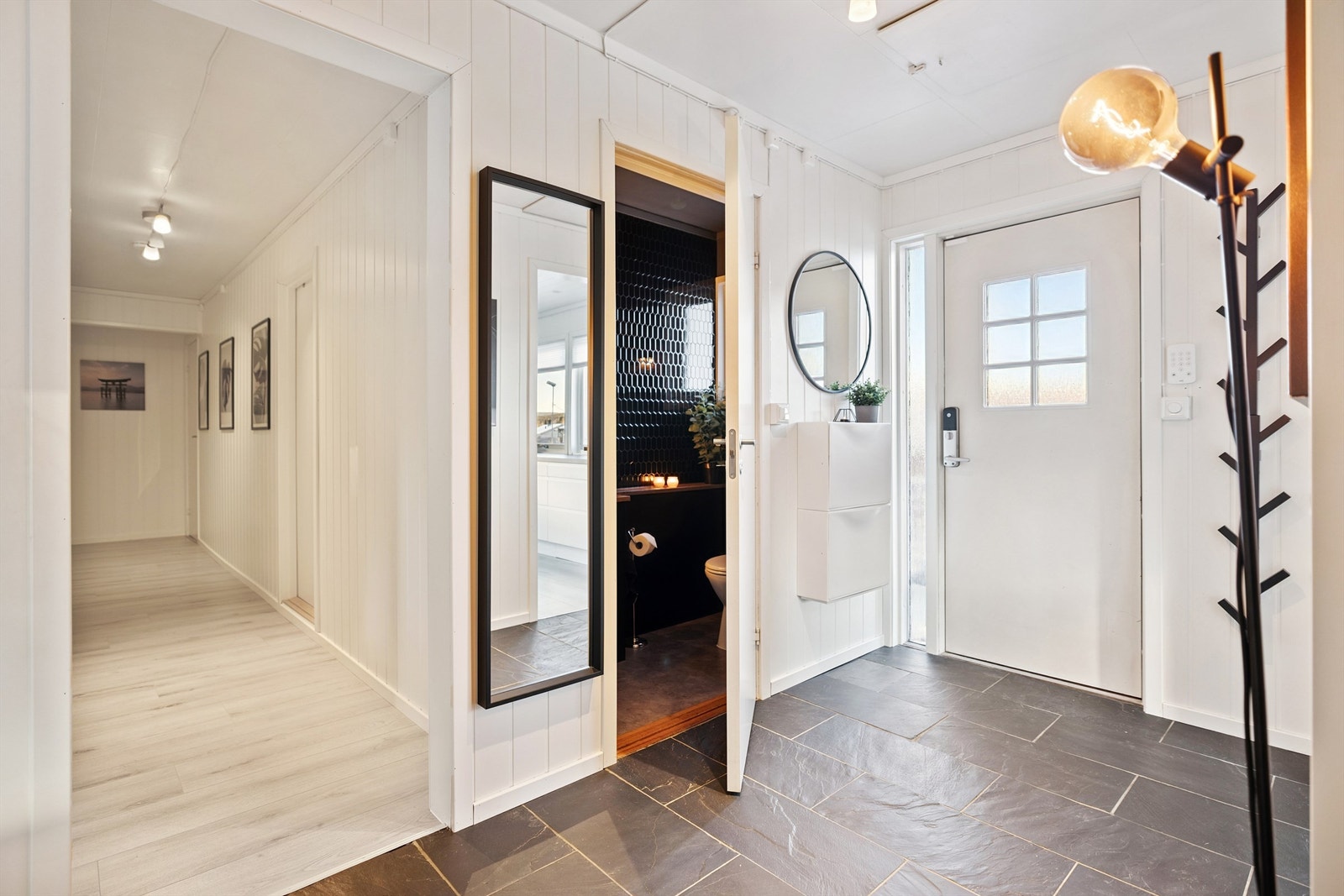 Fra entreen er det tilgang til et praktisk toalettrom og videre inn i boligens sosiale soner. Galleribilde