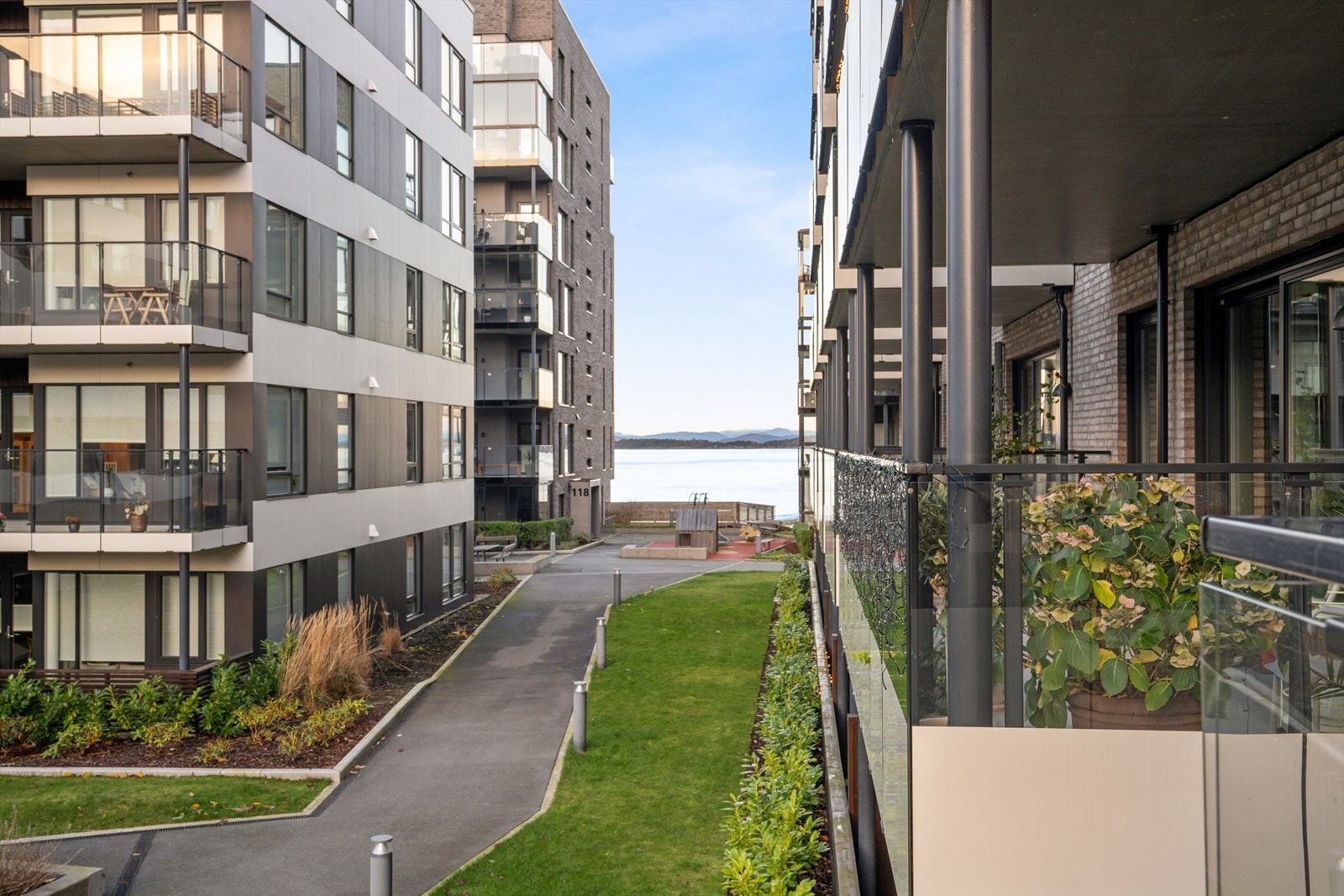 Fra balkongen har man flott utsikt mot sjøen og fellesområdet. Galleribilde